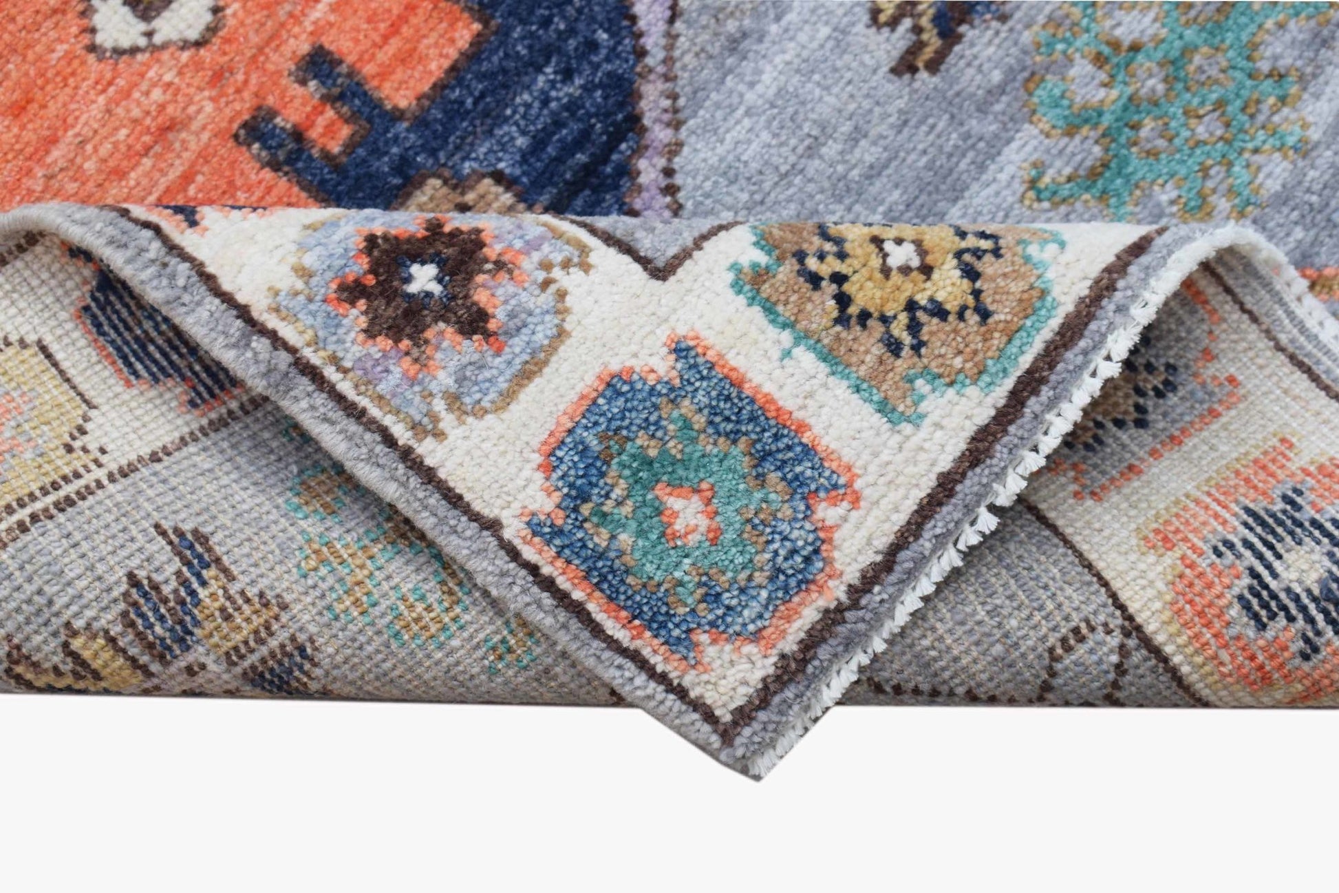 A handwoven transitional Oushak rug featuring a colorful geometric pattern on a light gray background.