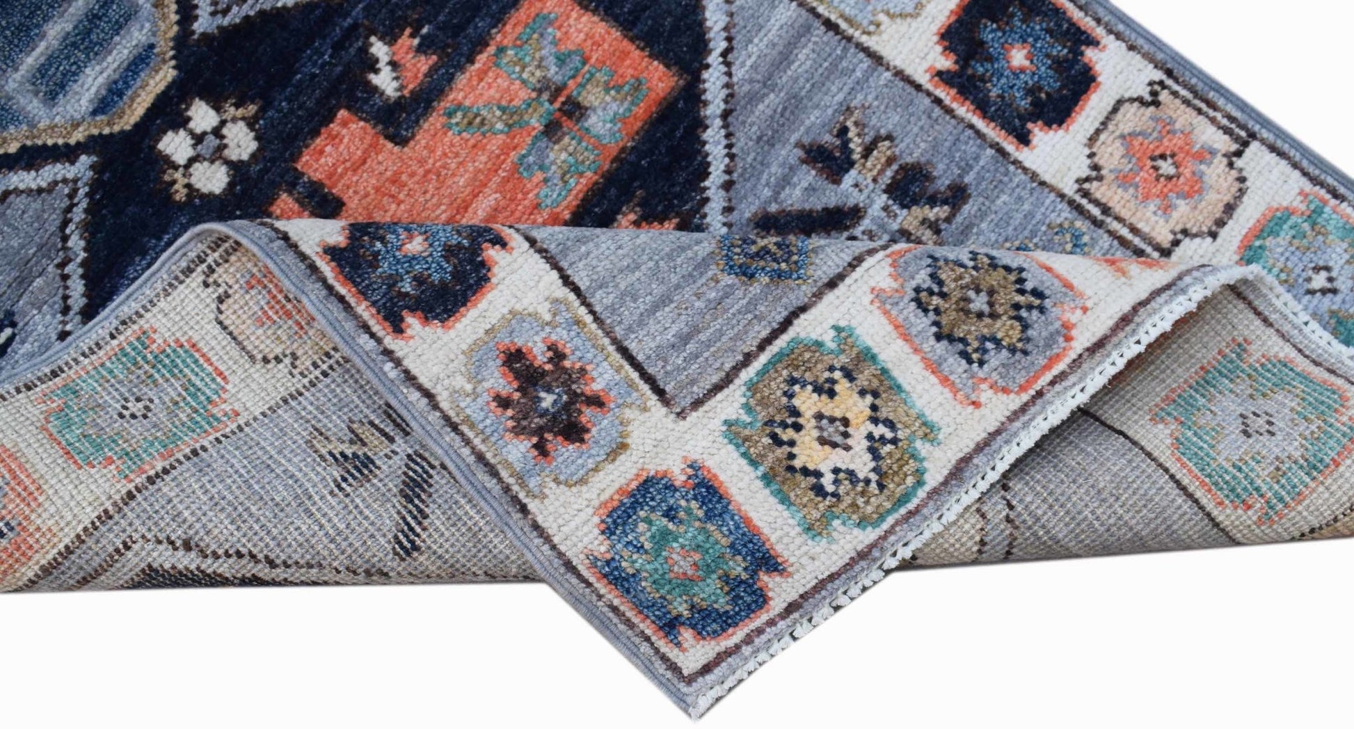 A handwoven transitional Oushak rug featuring a geometric floral pattern in blue and orange tones.