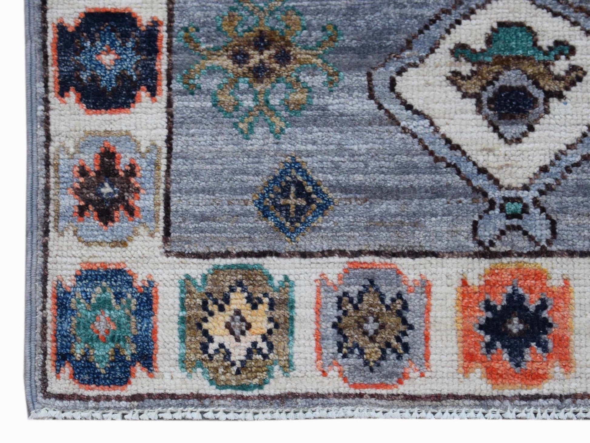 A handwoven transitional Oushak rug featuring a blue field with geometric and floral motifs.