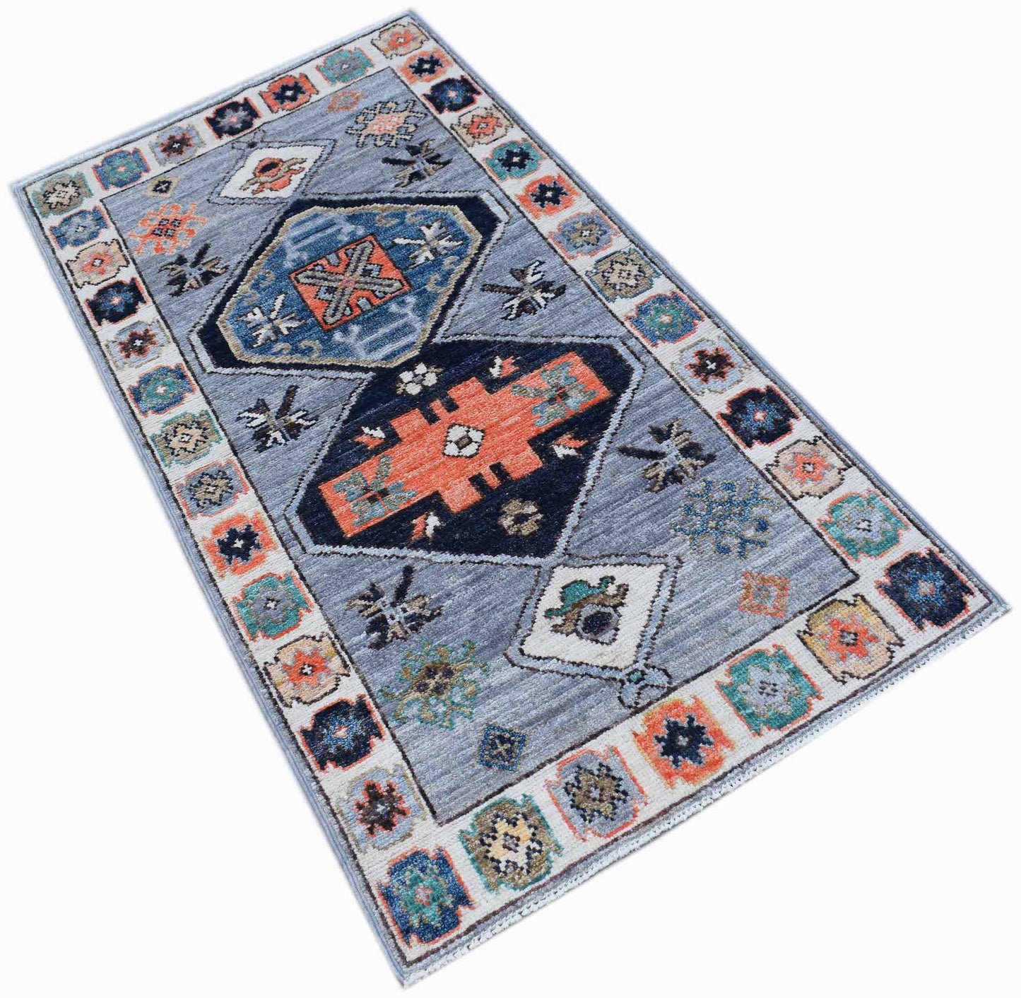 A handwoven transitional Oushak rug featuring a geometric pattern in blue, orange, and cream.