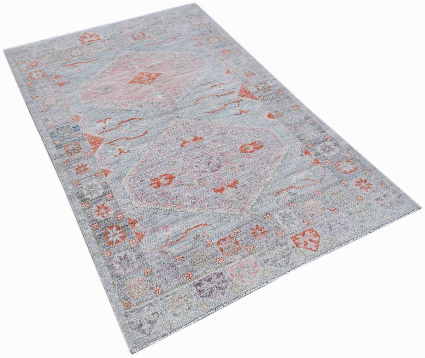 A handwoven transitional Oushak rug featuring a light blue field with pink and orange floral motifs.