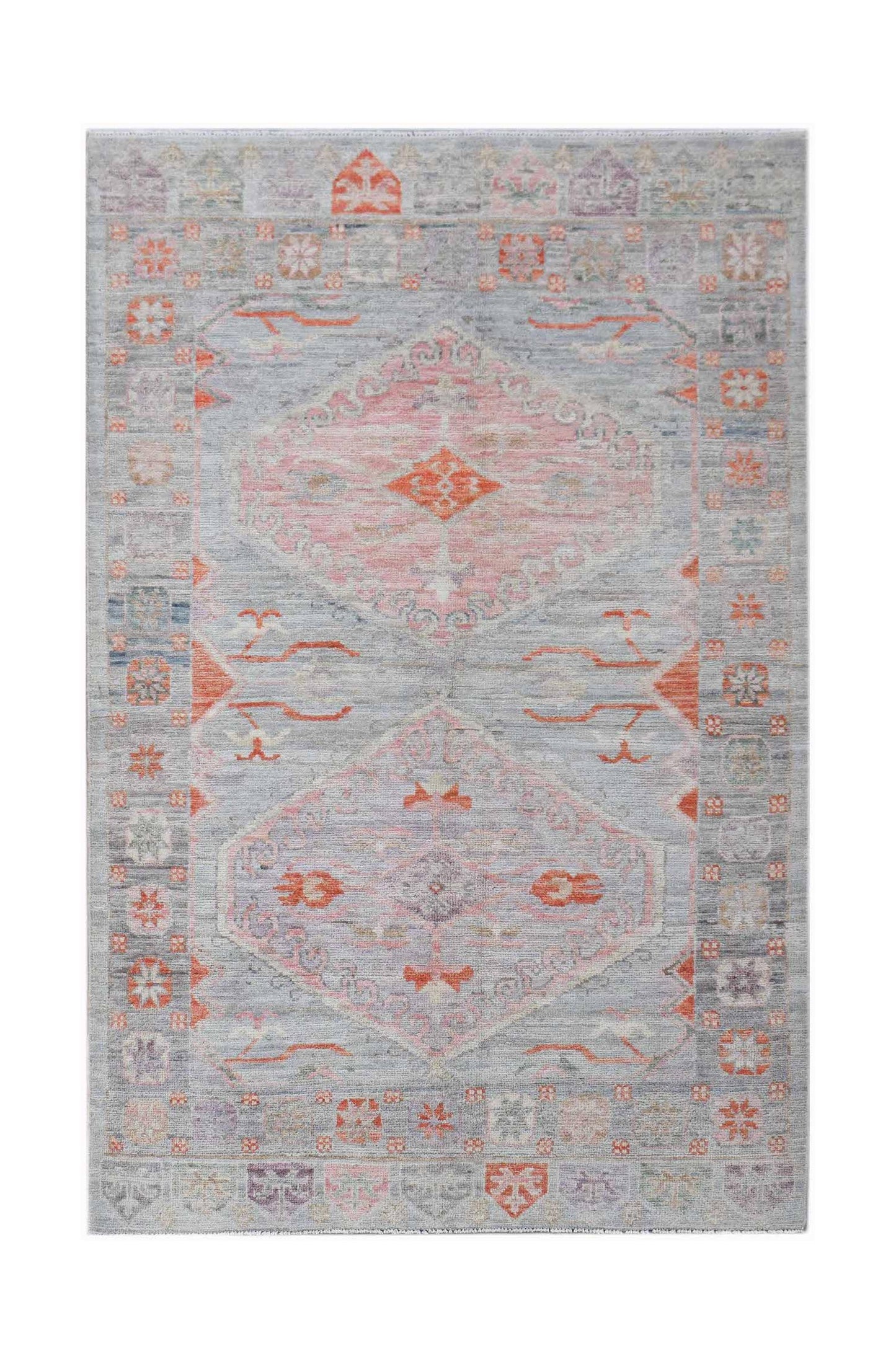 A handwoven transitional Oushak rug featuring a light grey field with pink and orange motifs.