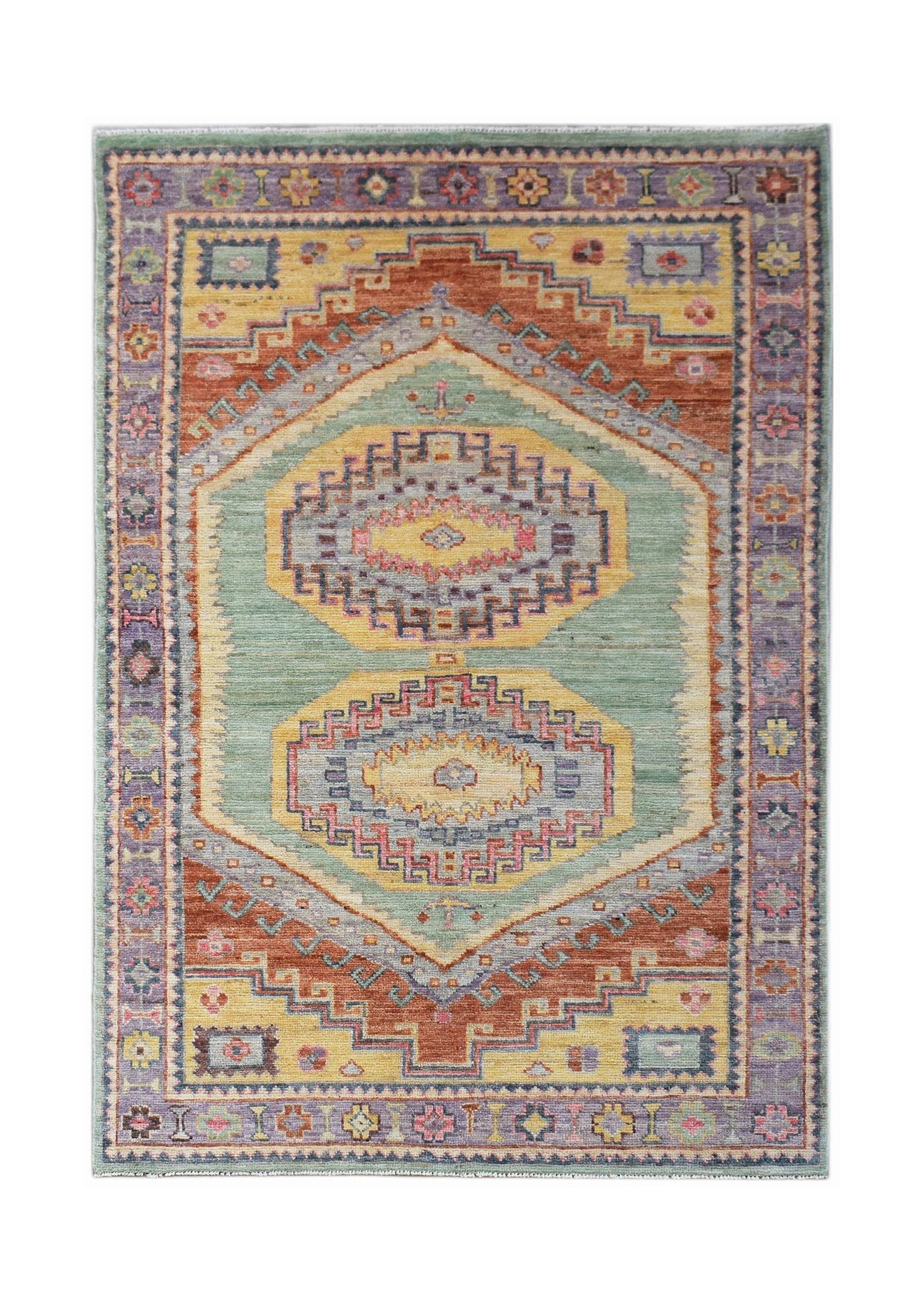 A handwoven transitional Oushak rug featuring geometric medallions in a muted, multi-colored palette.