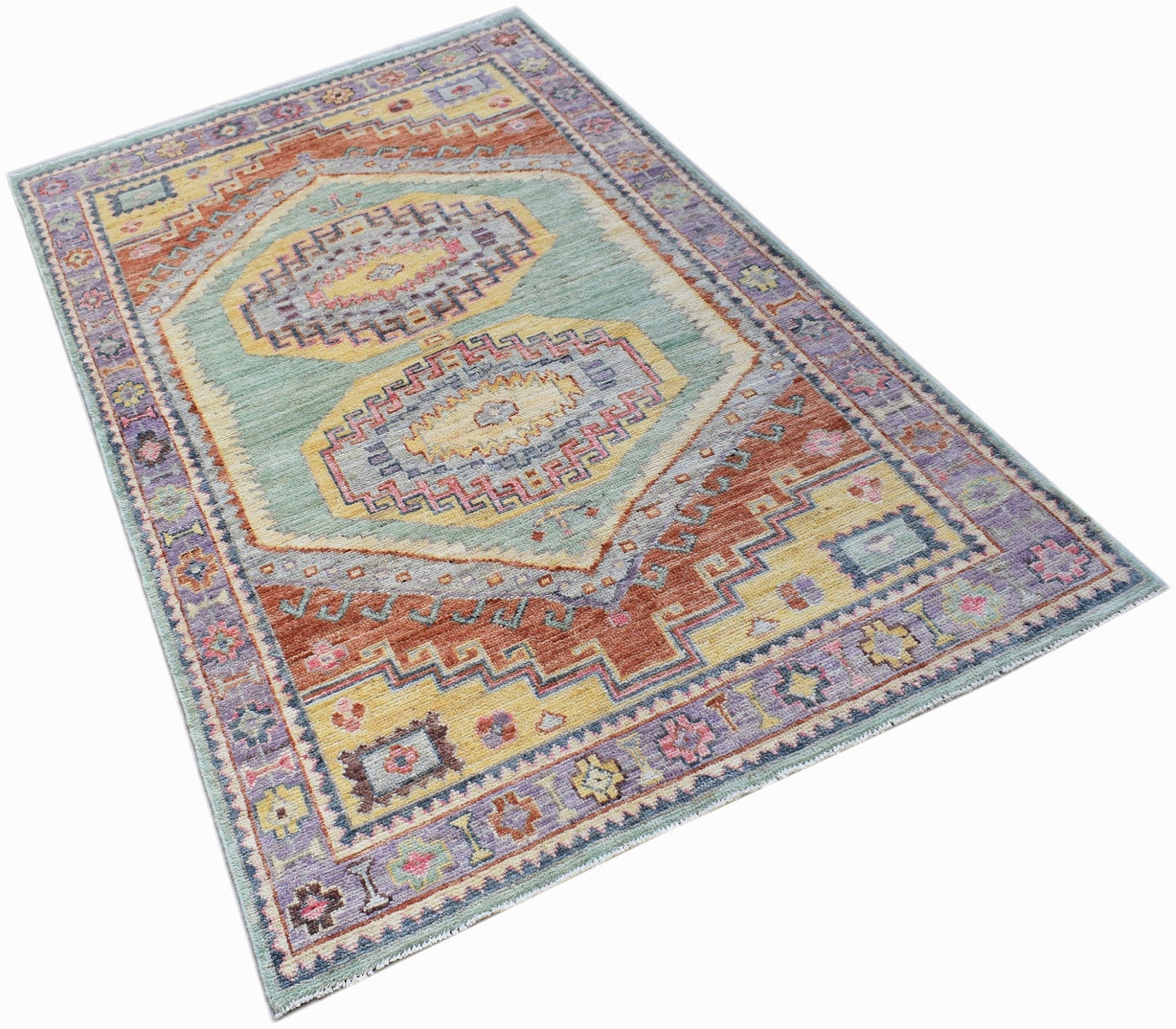 A handwoven transitional Oushak rug featuring a geometric pattern in soft blue, yellow, and rust.