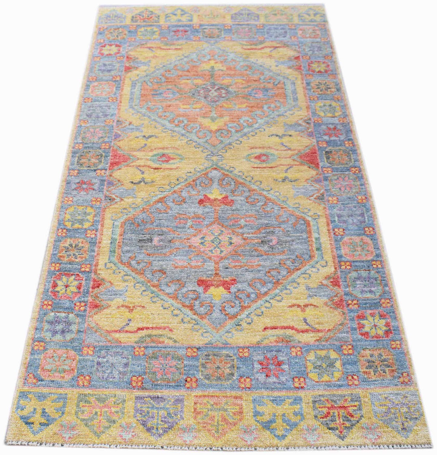 A handwoven transitional Oushak rug featuring a floral pattern in blue, yellow, and orange tones.