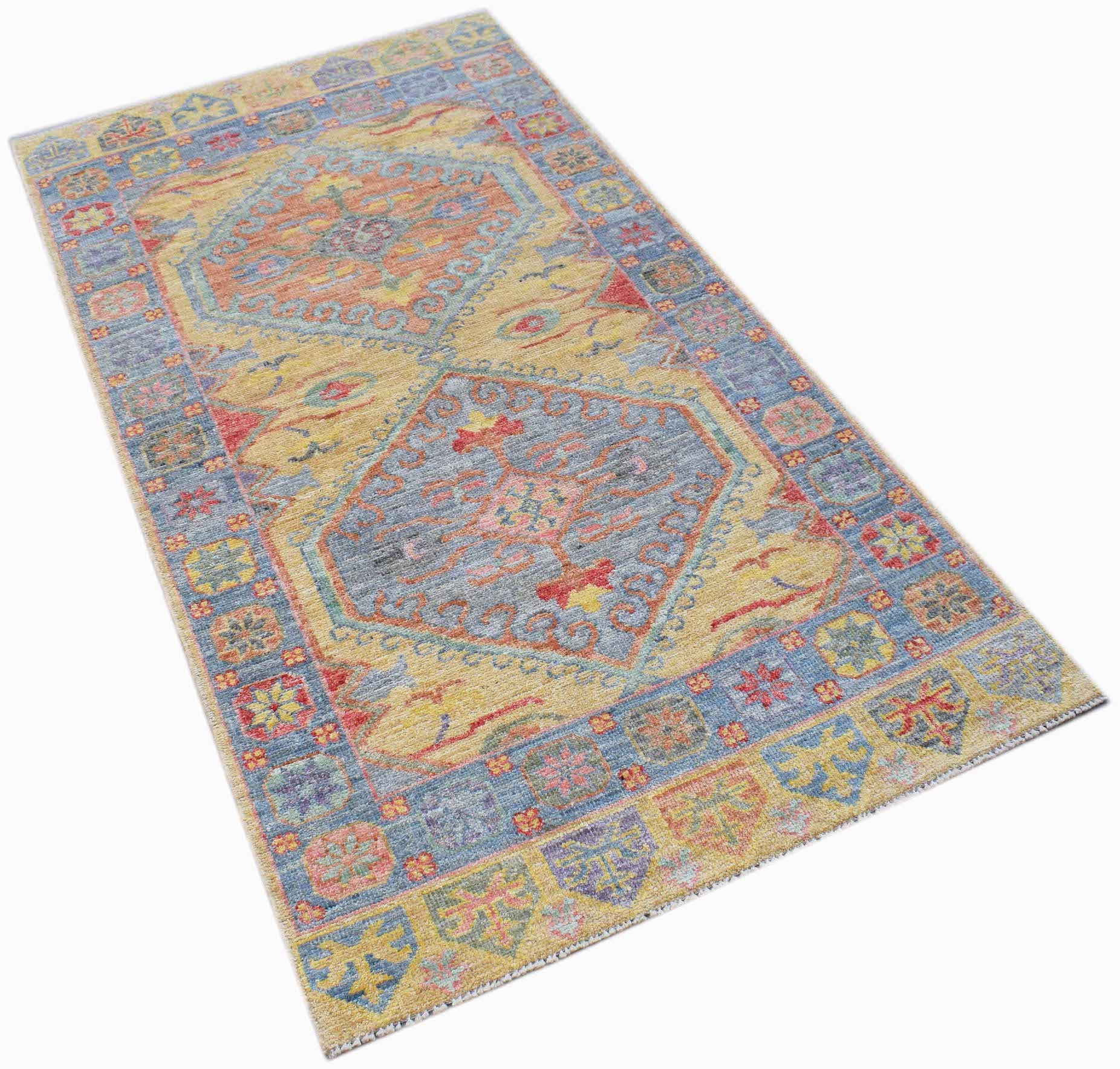 A handwoven transitional Oushak rug featuring a floral pattern in blue, yellow, and red tones.