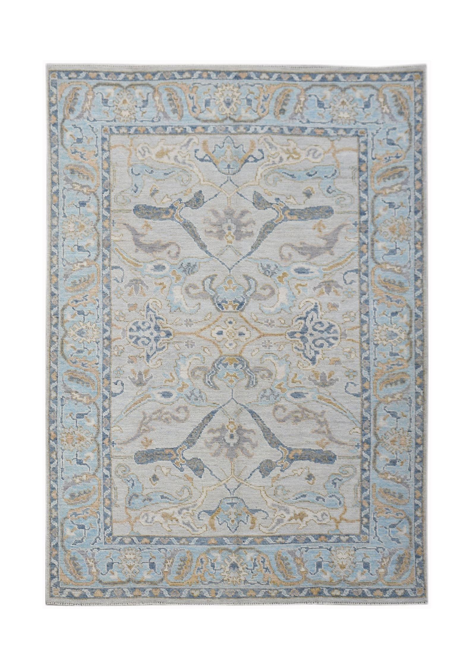 A handwoven transitional Oushak rug featuring a light blue and beige floral pattern.