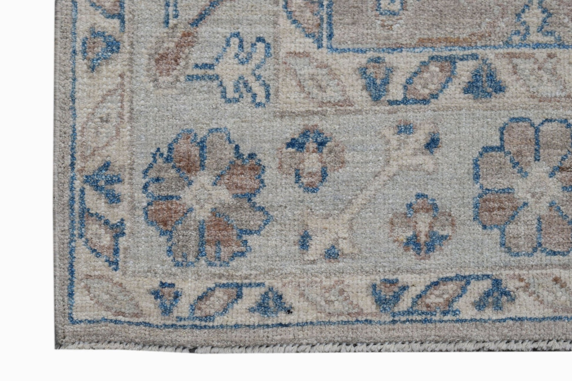 A handwoven transitional Oushak rug featuring a floral pattern in blue and beige tones.