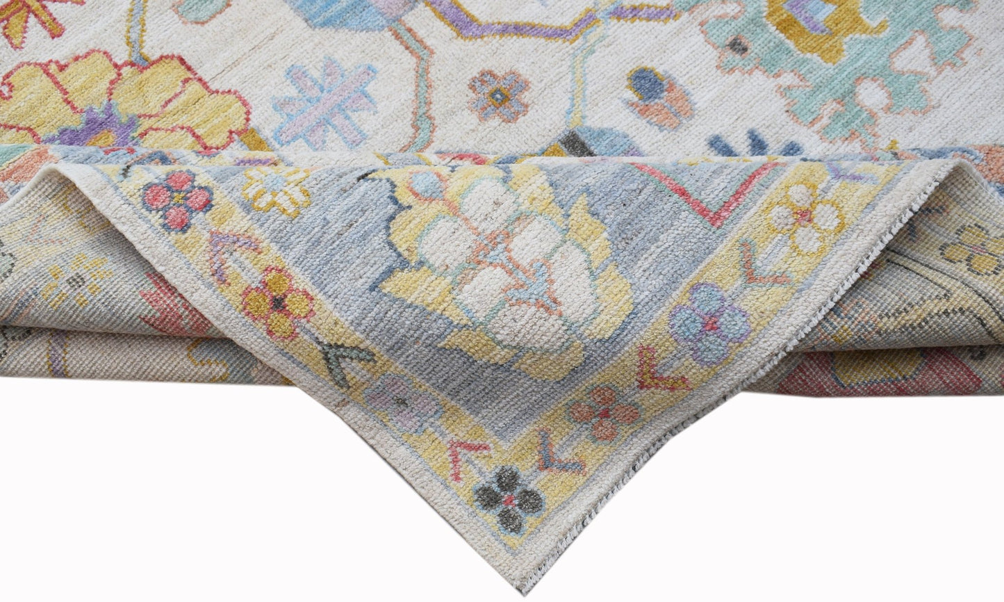 A handwoven transitional Oushak rug featuring a floral pattern in soft, contemporary colors.