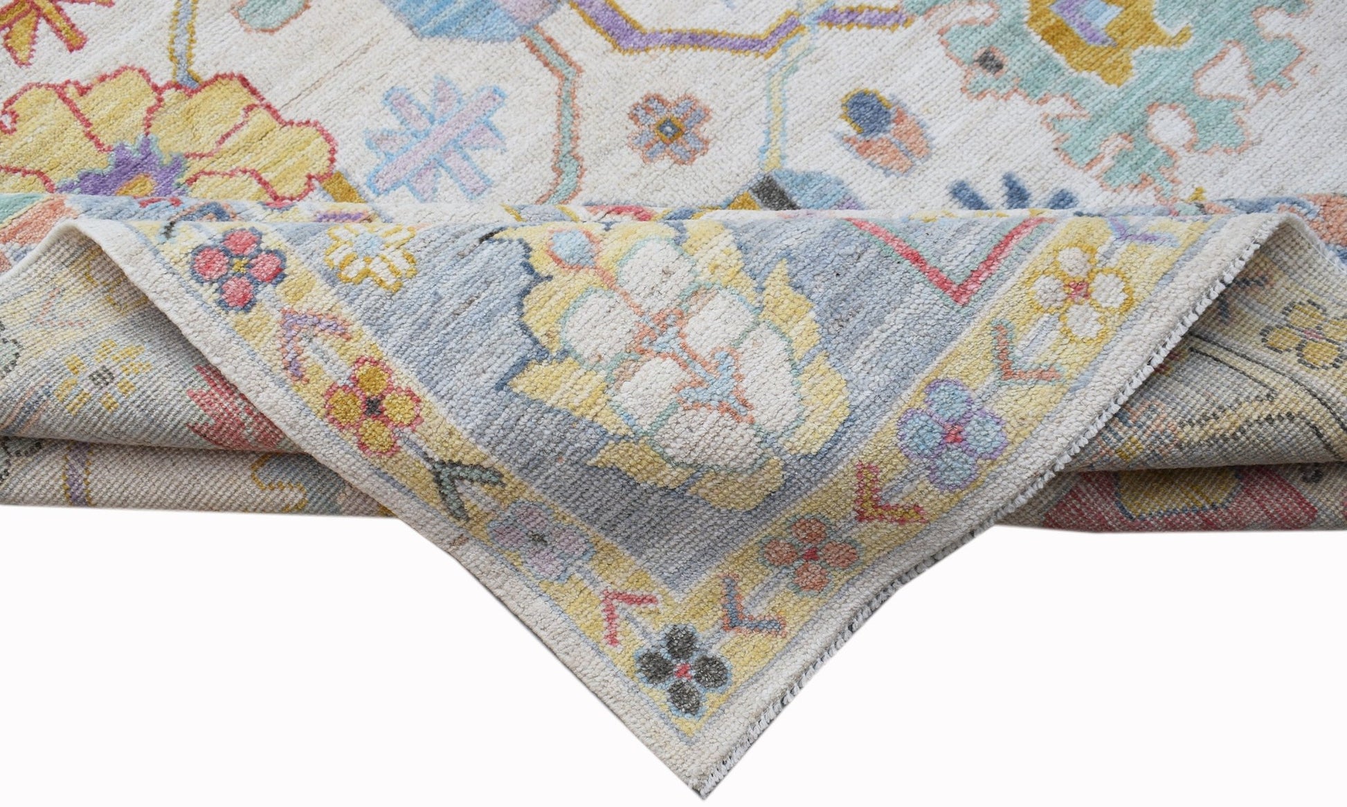 A handwoven transitional Oushak rug featuring a floral pattern in soft, contemporary colors.