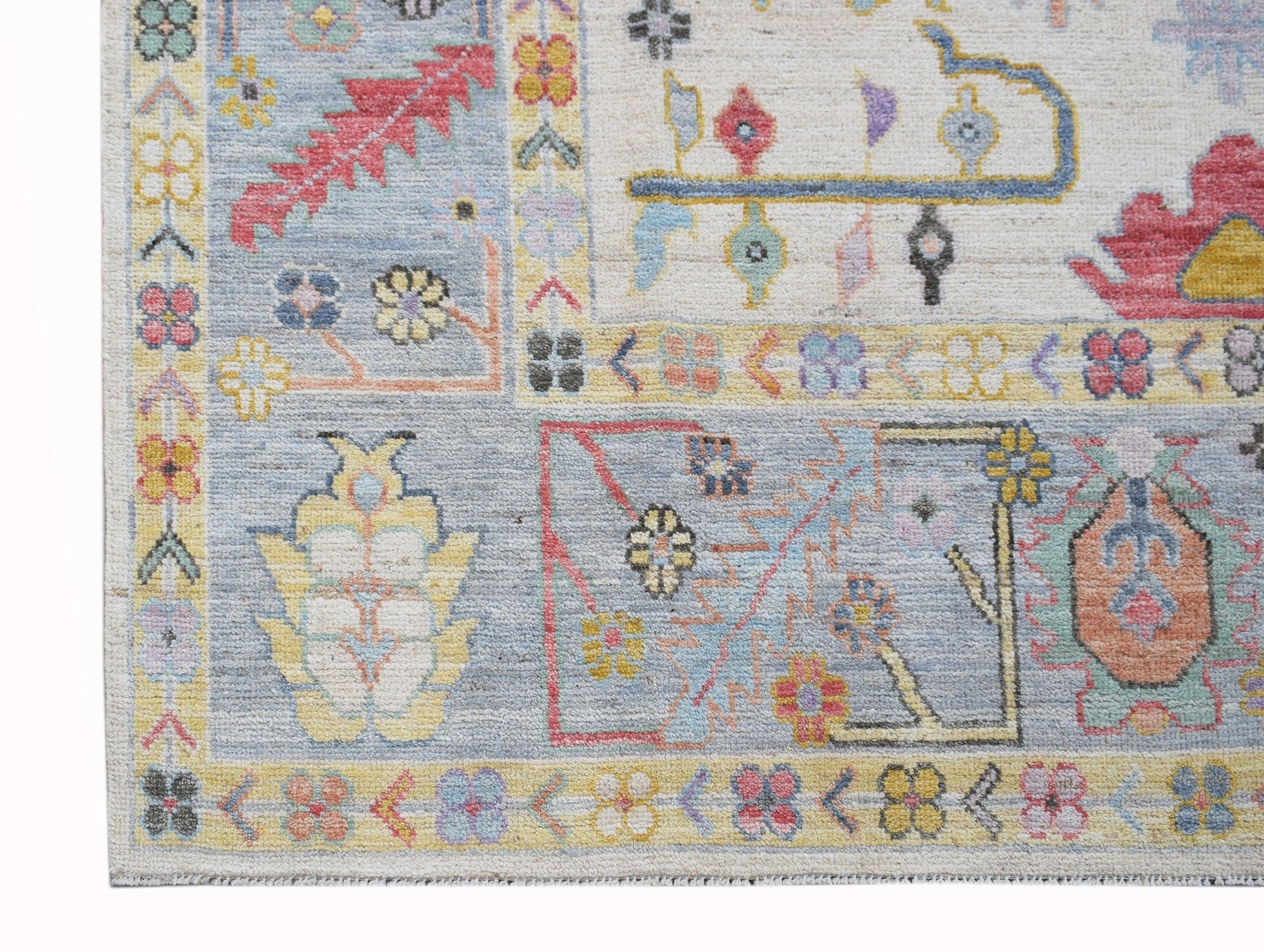 A handwoven transitional Oushak rug featuring a floral pattern in soft blue and neutral tones.