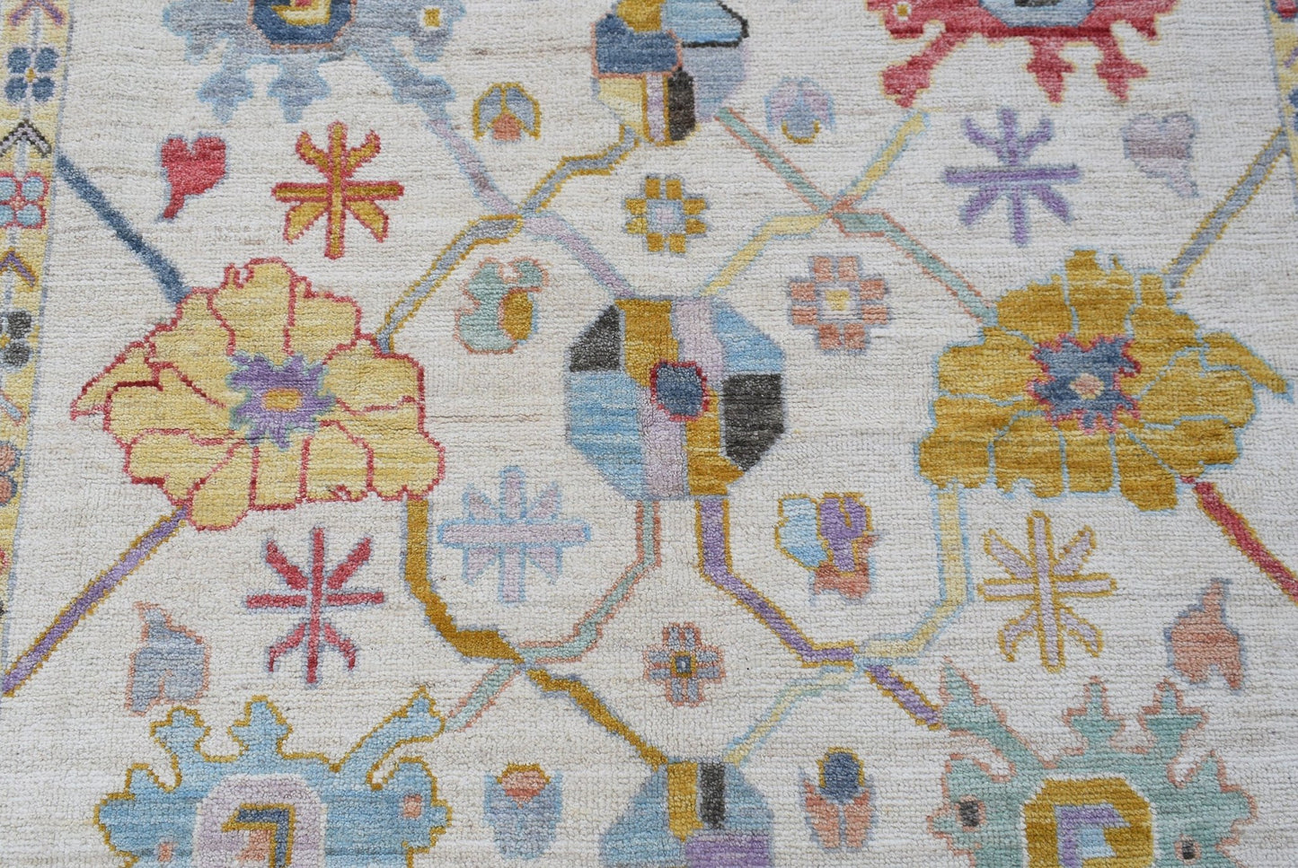 A handwoven transitional Oushak rug featuring a floral pattern in soft, contemporary colors.