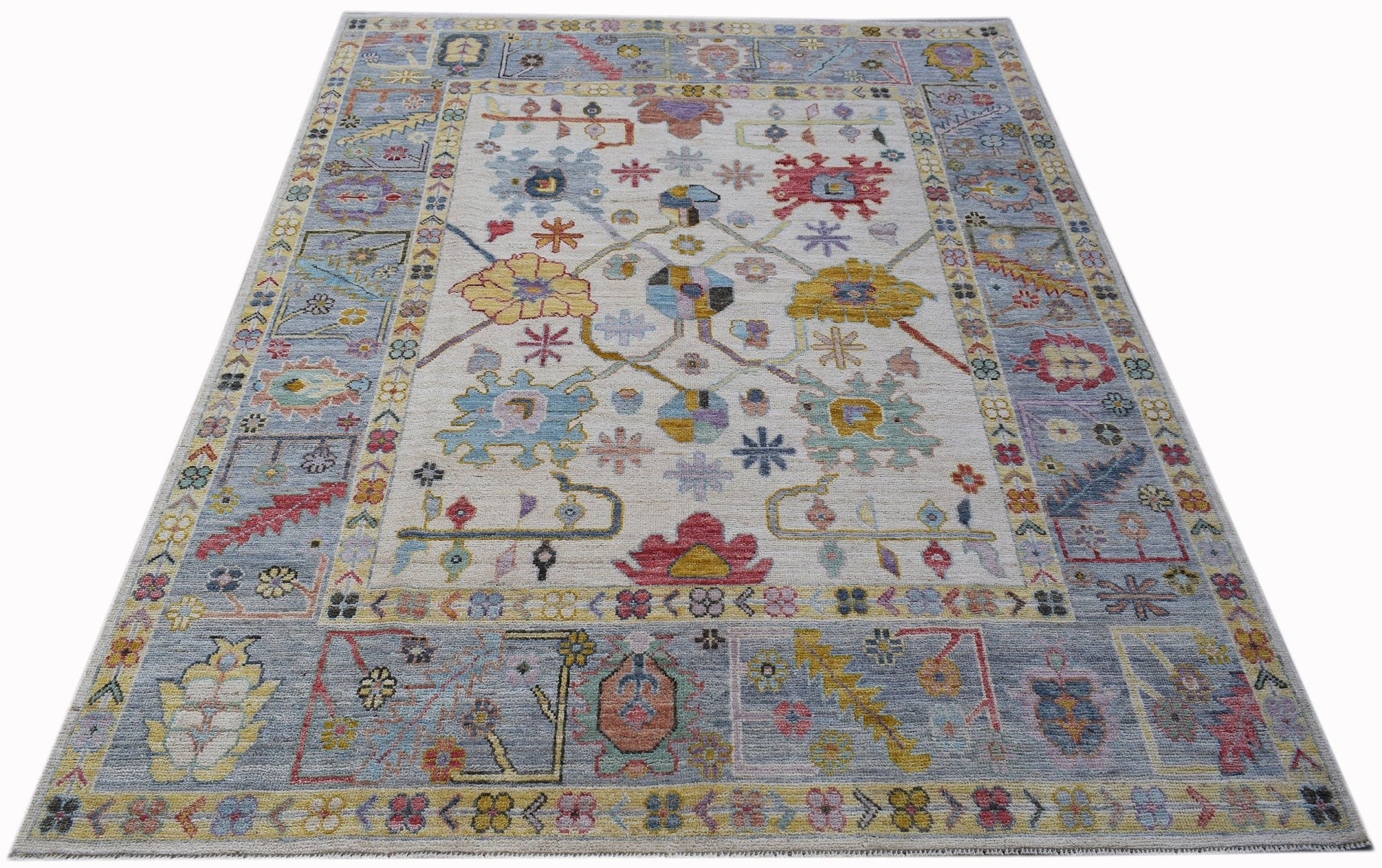 A handwoven transitional Oushak rug featuring a floral pattern in soft, contemporary colors.