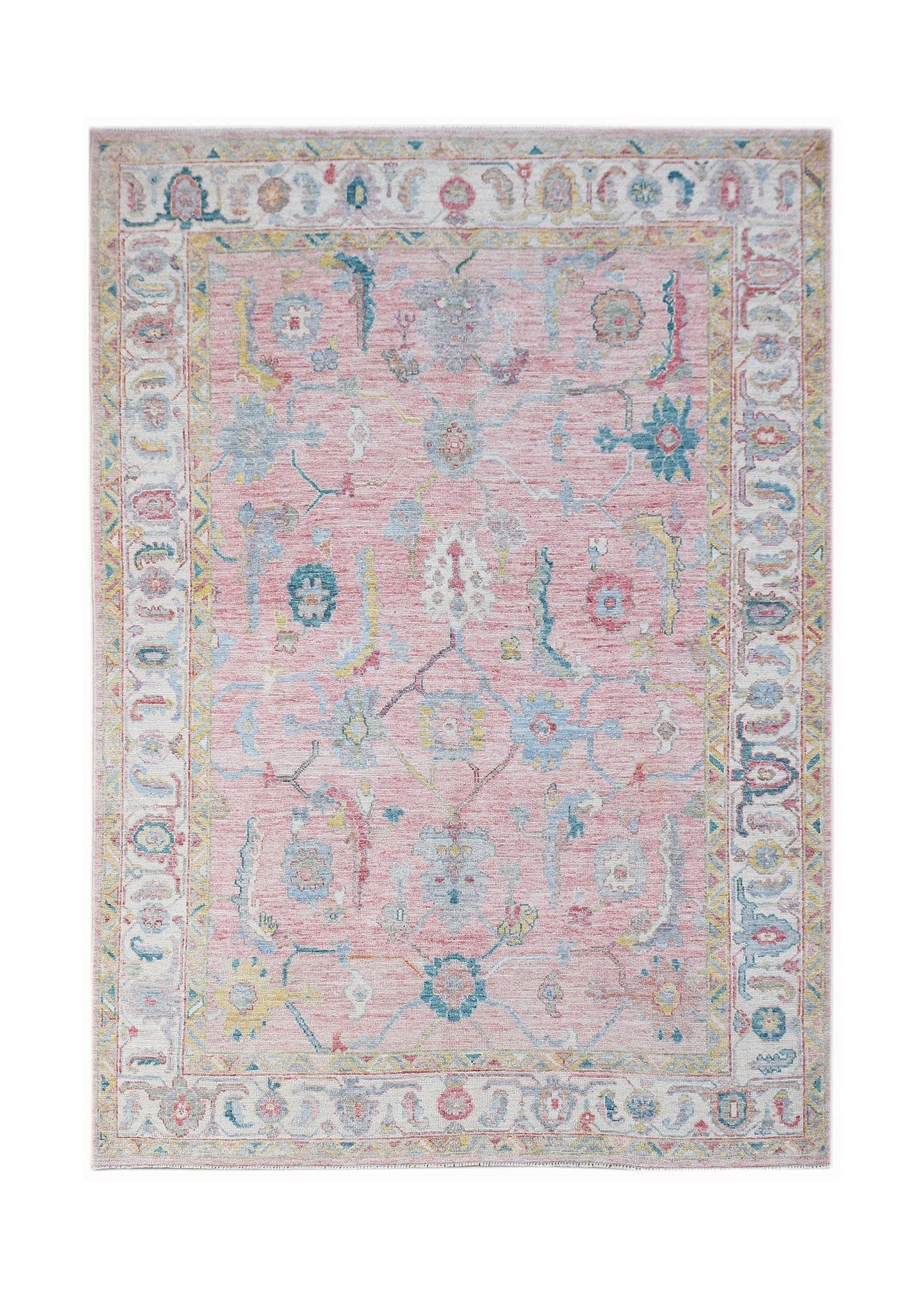 A handwoven transitional Oushak rug featuring a floral pattern in soft pink, blue, and yellow tones.