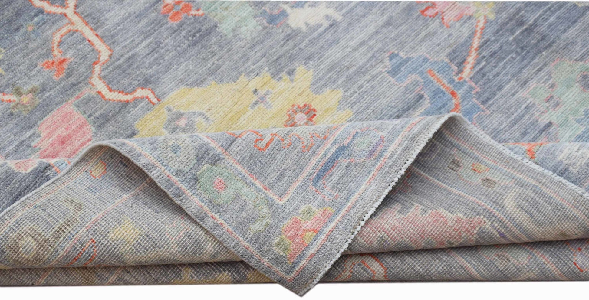 A handwoven transitional Oushak rug in blue with a floral pattern and contemporary color accents.