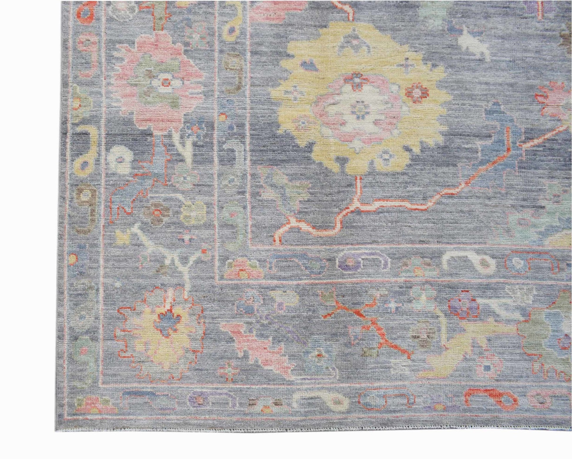 A handwoven transitional Oushak rug featuring a floral pattern in soft pastel tones on a grey base.