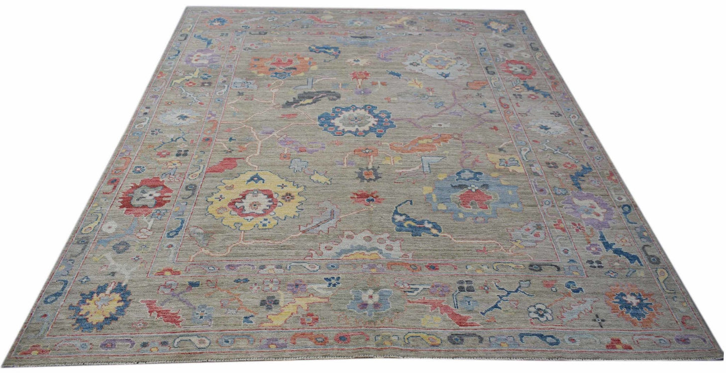 A handwoven transitional Oushak rug featuring a floral pattern in multi-colored wool on a grey base.