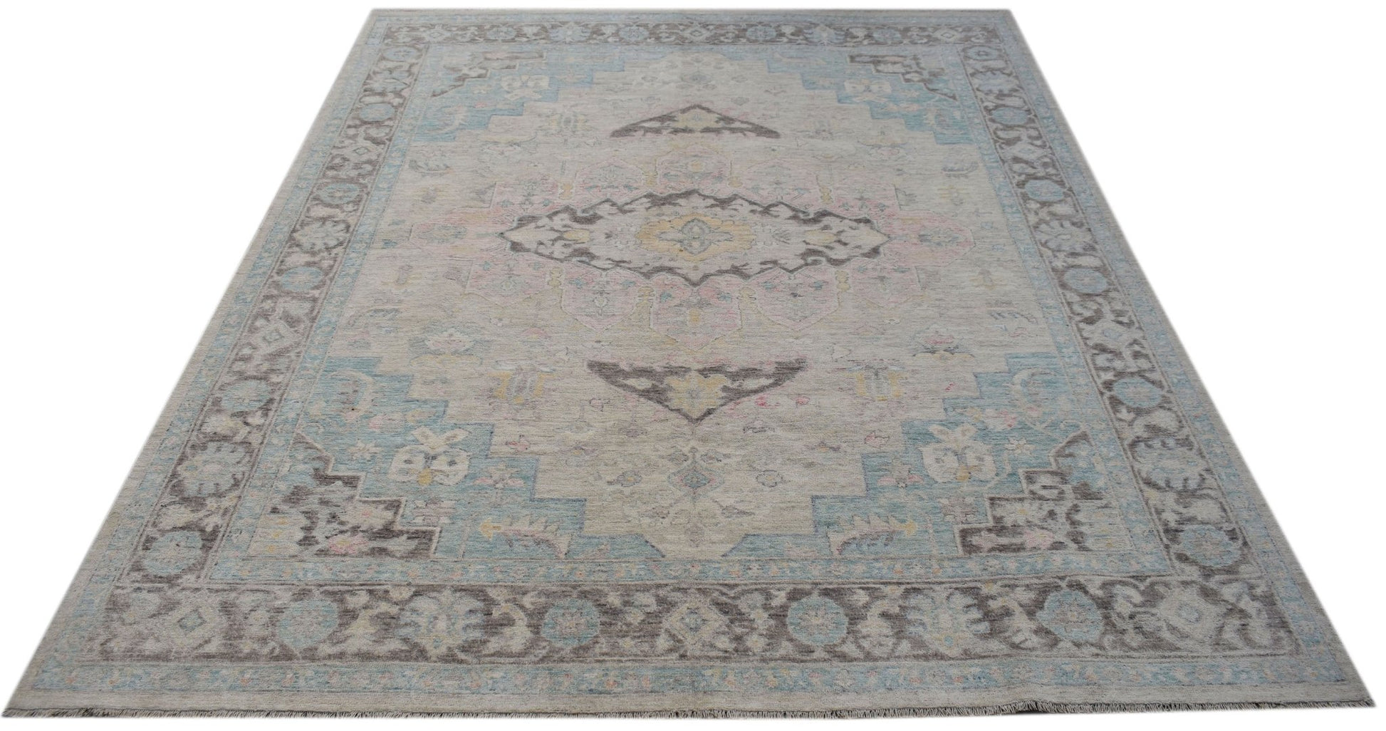 A handwoven transitional Oushak rug featuring a light grey field with blue and brown floral motifs.