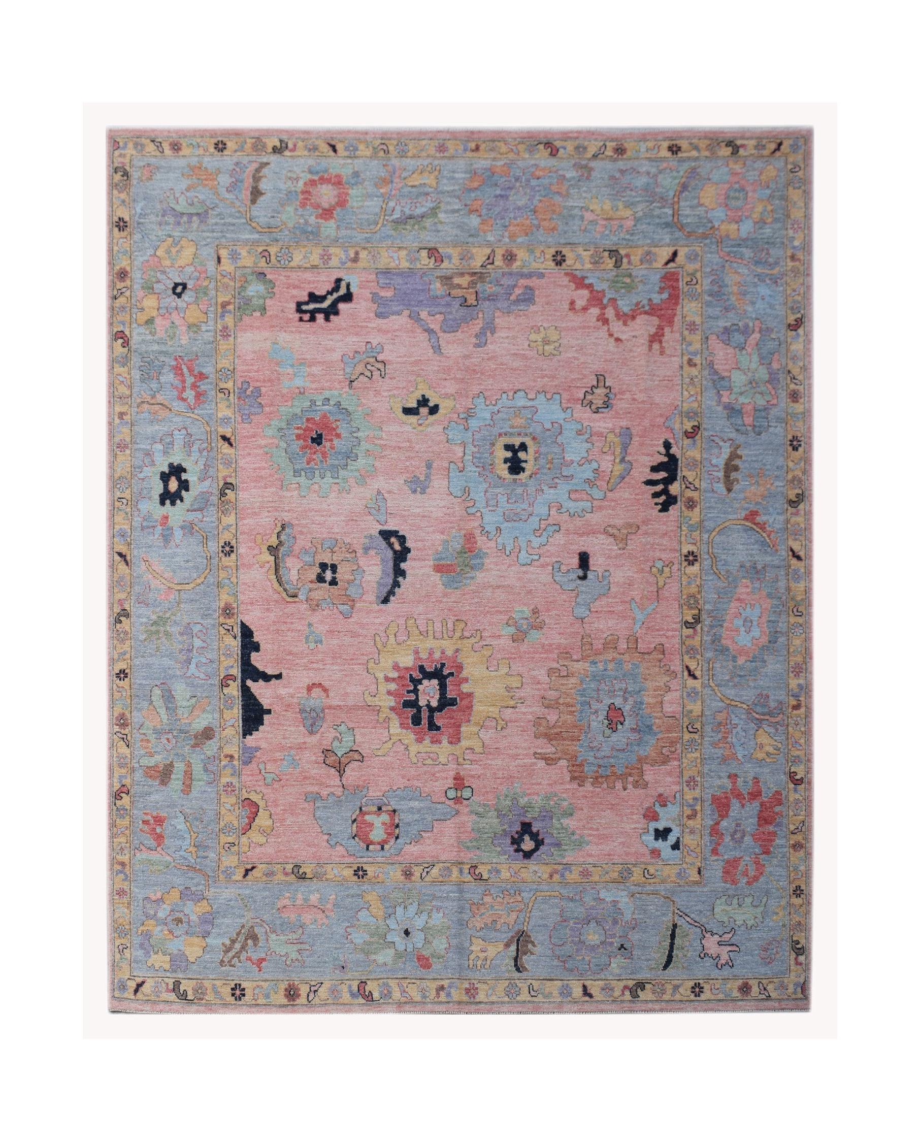 A handwoven transitional Oushak rug featuring a floral pattern in pink and blue tones.