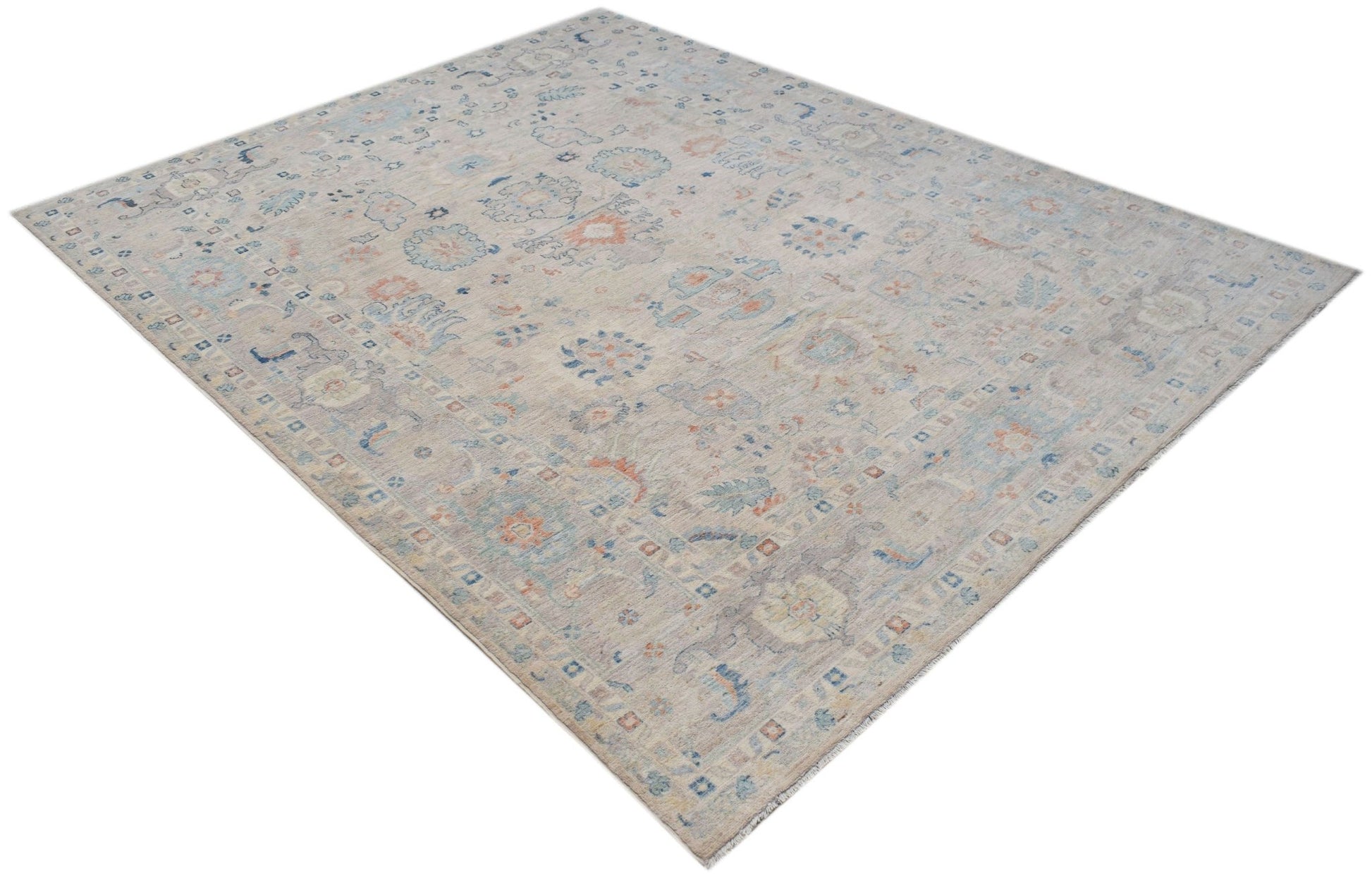 A handwoven transitional Oushak rug featuring a light floral pattern in soft blue and orange tones.