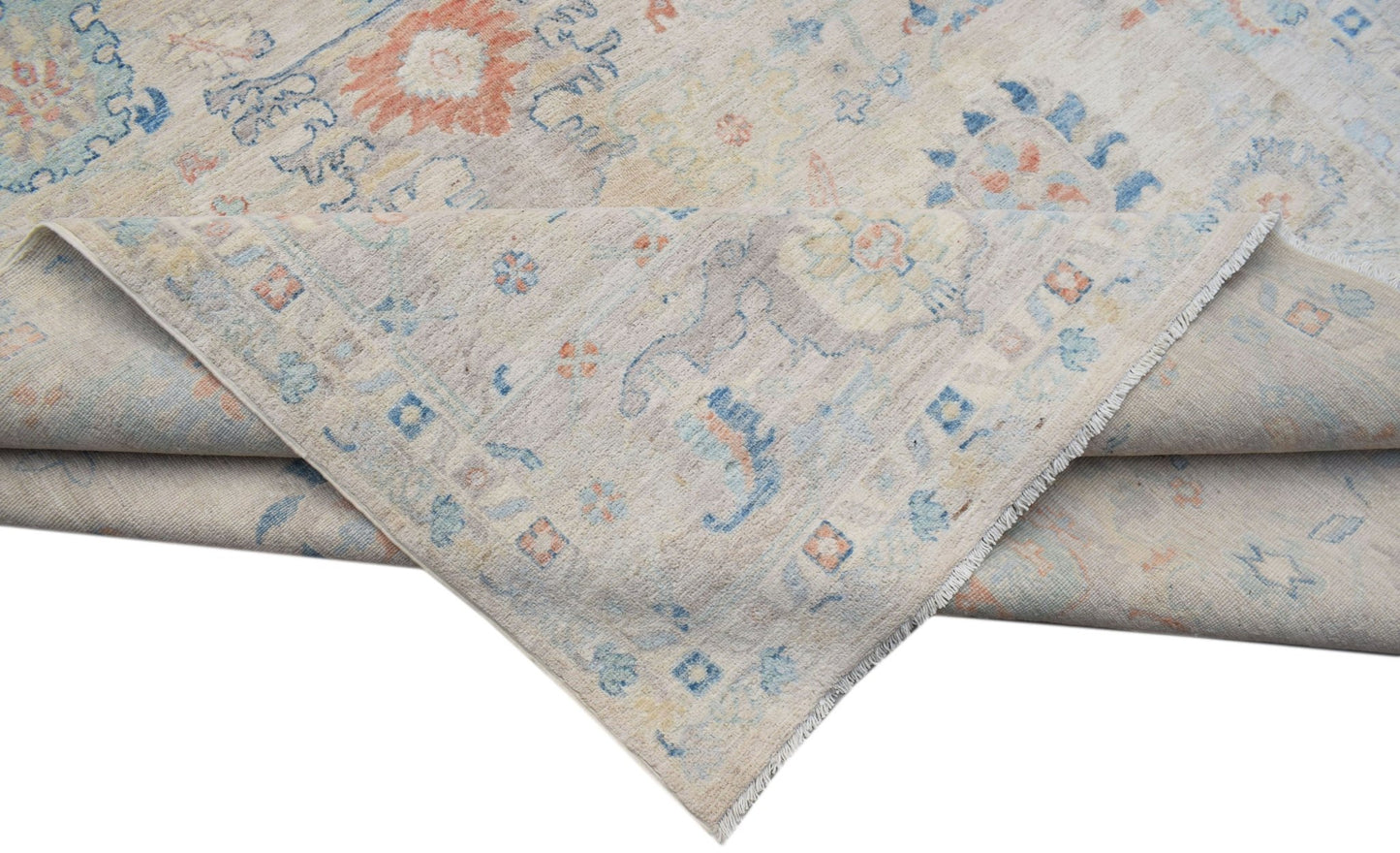 A handwoven transitional Oushak rug featuring a floral pattern in soft blue, orange, and beige.