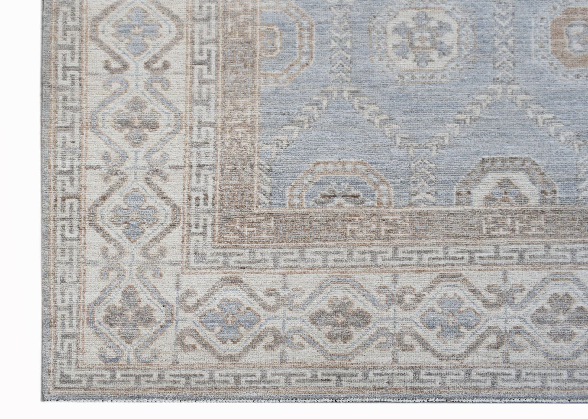 A handwoven transitional Oushak rug featuring a light blue and beige geometric floral pattern.