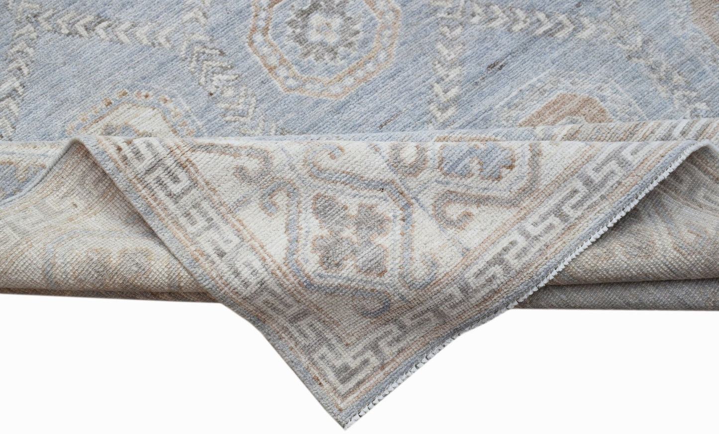 A handwoven transitional Oushak rug in light blue and beige with a traditional floral pattern.