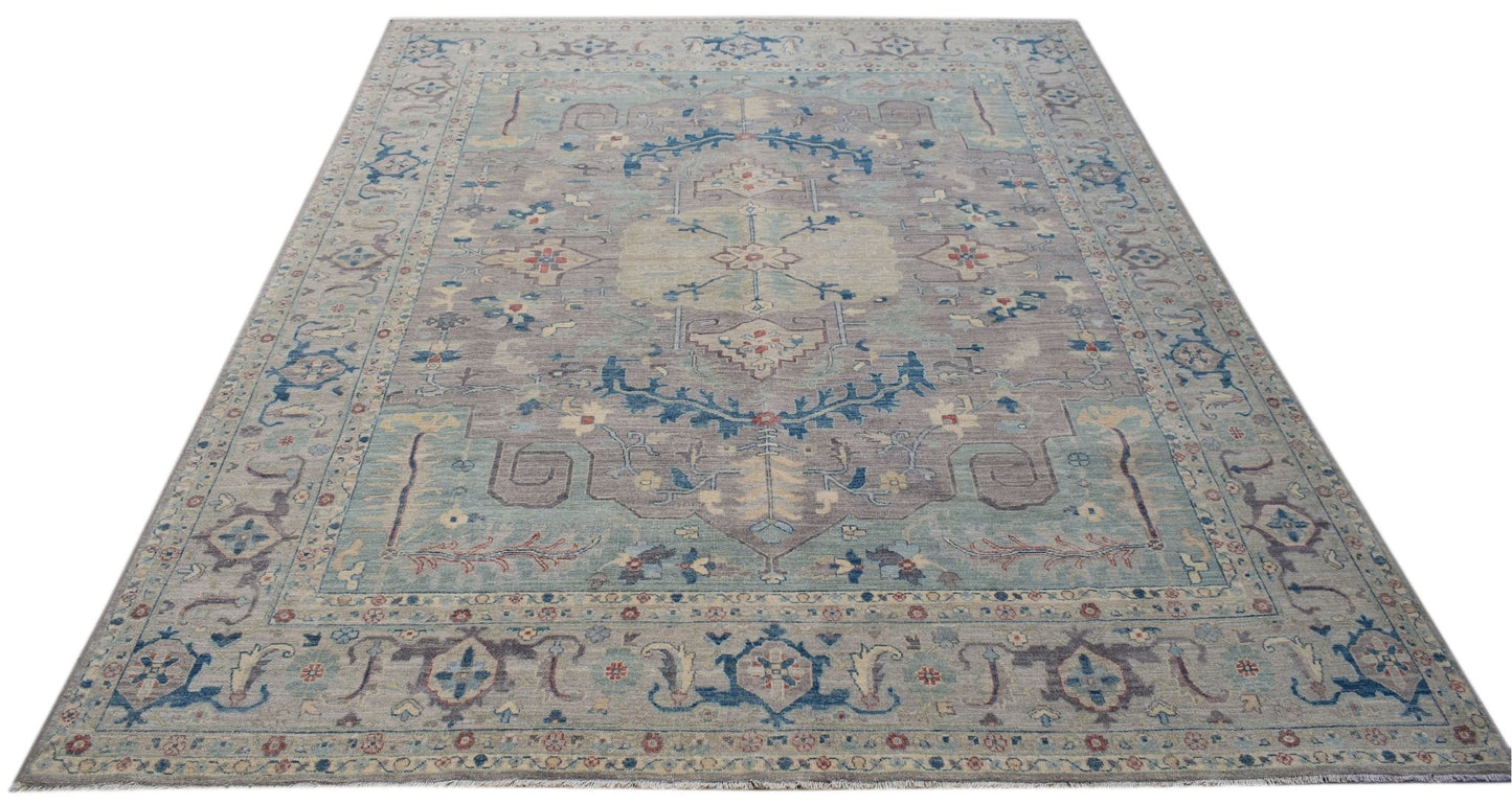 A handwoven transitional Oushak rug featuring a floral pattern in muted blue and grey tones.