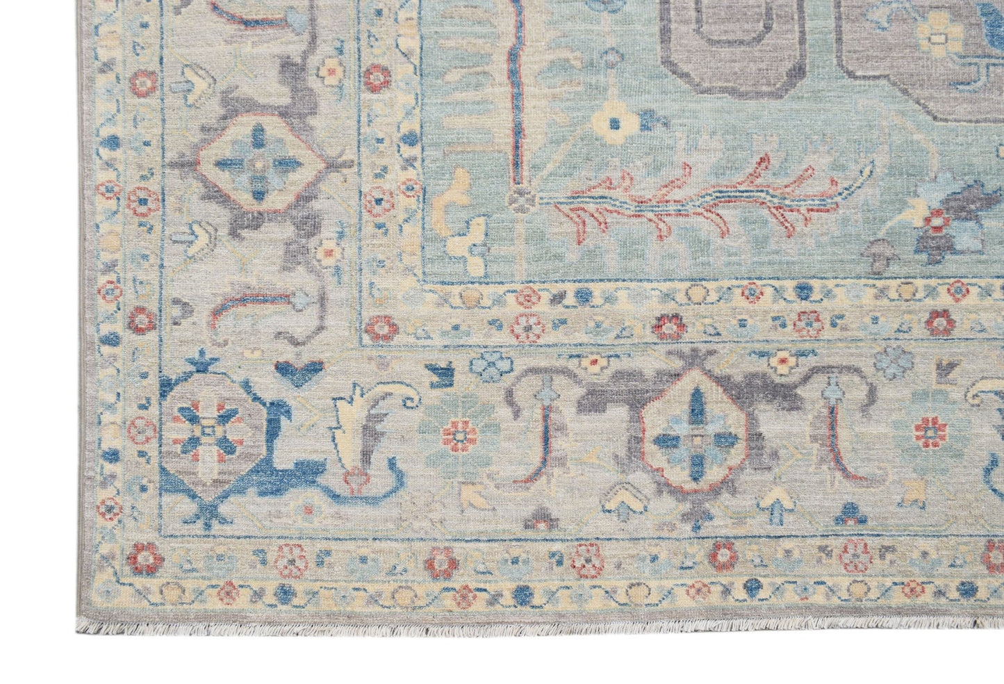 A handwoven transitional Oushak rug featuring a floral pattern in blue, grey, and cream tones.