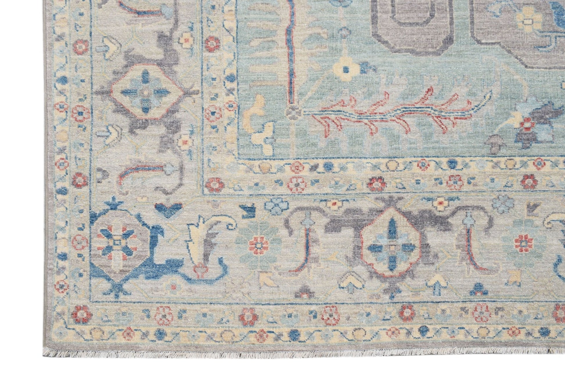A handwoven transitional Oushak rug featuring a floral pattern in blue, grey, and cream tones.