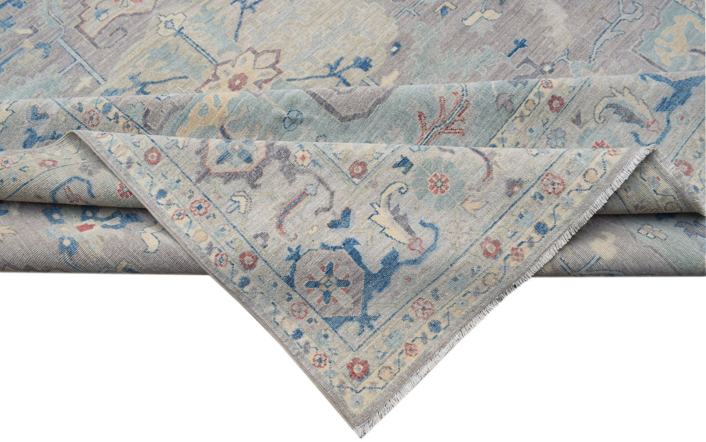 A handwoven transitional Oushak rug featuring a floral pattern in soft blue and grey tones.