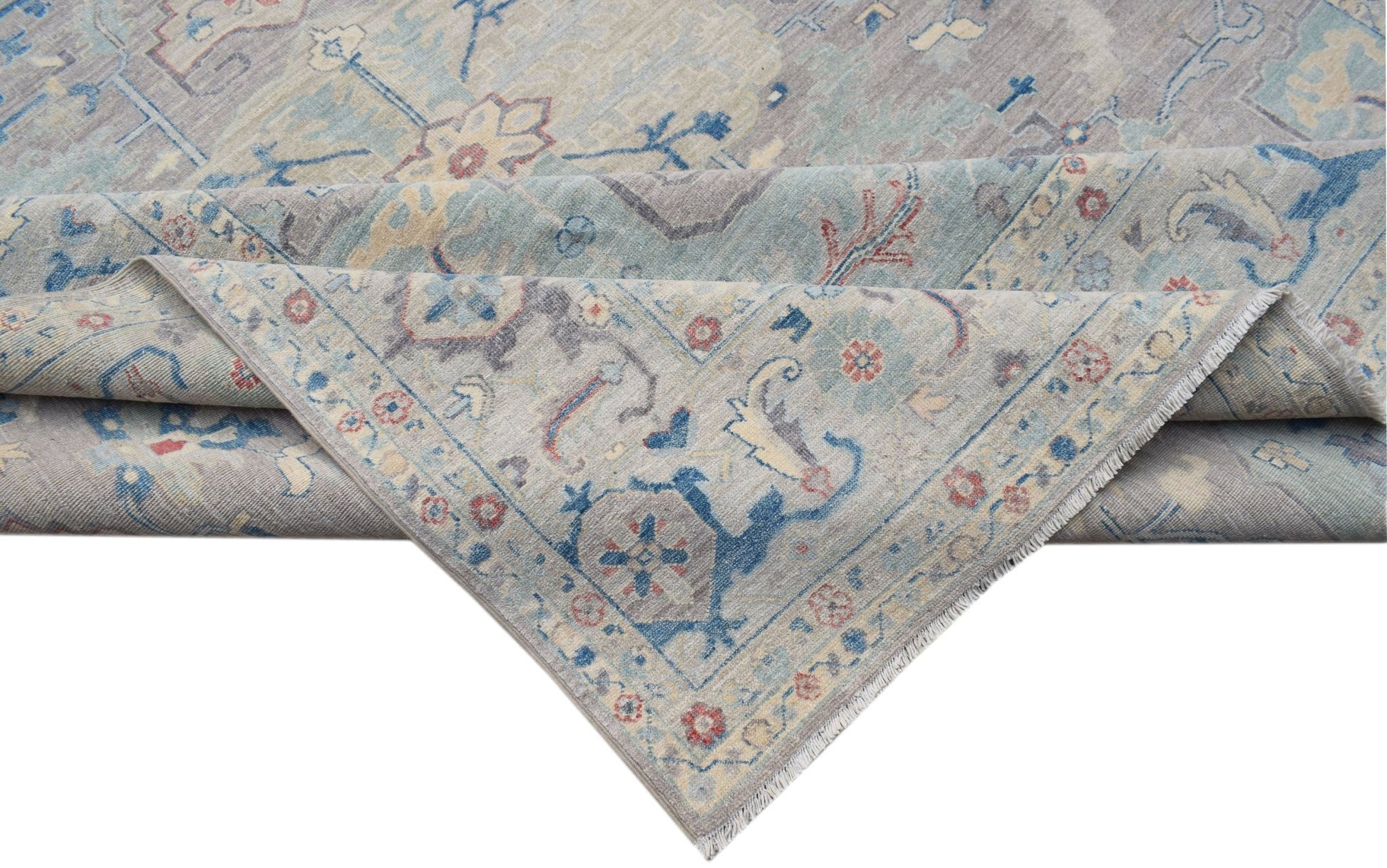 A handwoven transitional Oushak rug featuring a floral pattern in soft blue and grey tones.
