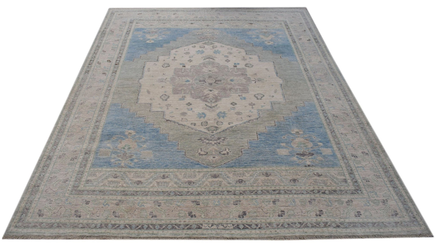 A handwoven transitional Oushak rug featuring a blue and cream floral medallion pattern.