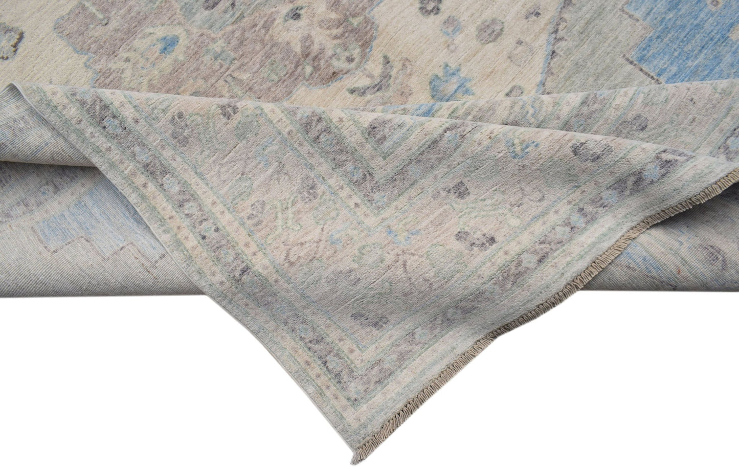 A handwoven transitional Oushak rug featuring a floral pattern in blue, grey, and cream tones.