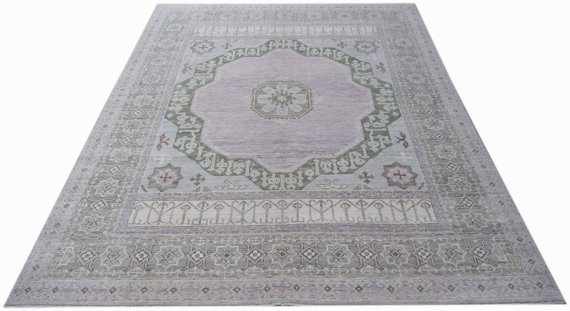 A handwoven transitional Oushak rug featuring a central medallion in soft lavender and sage green.