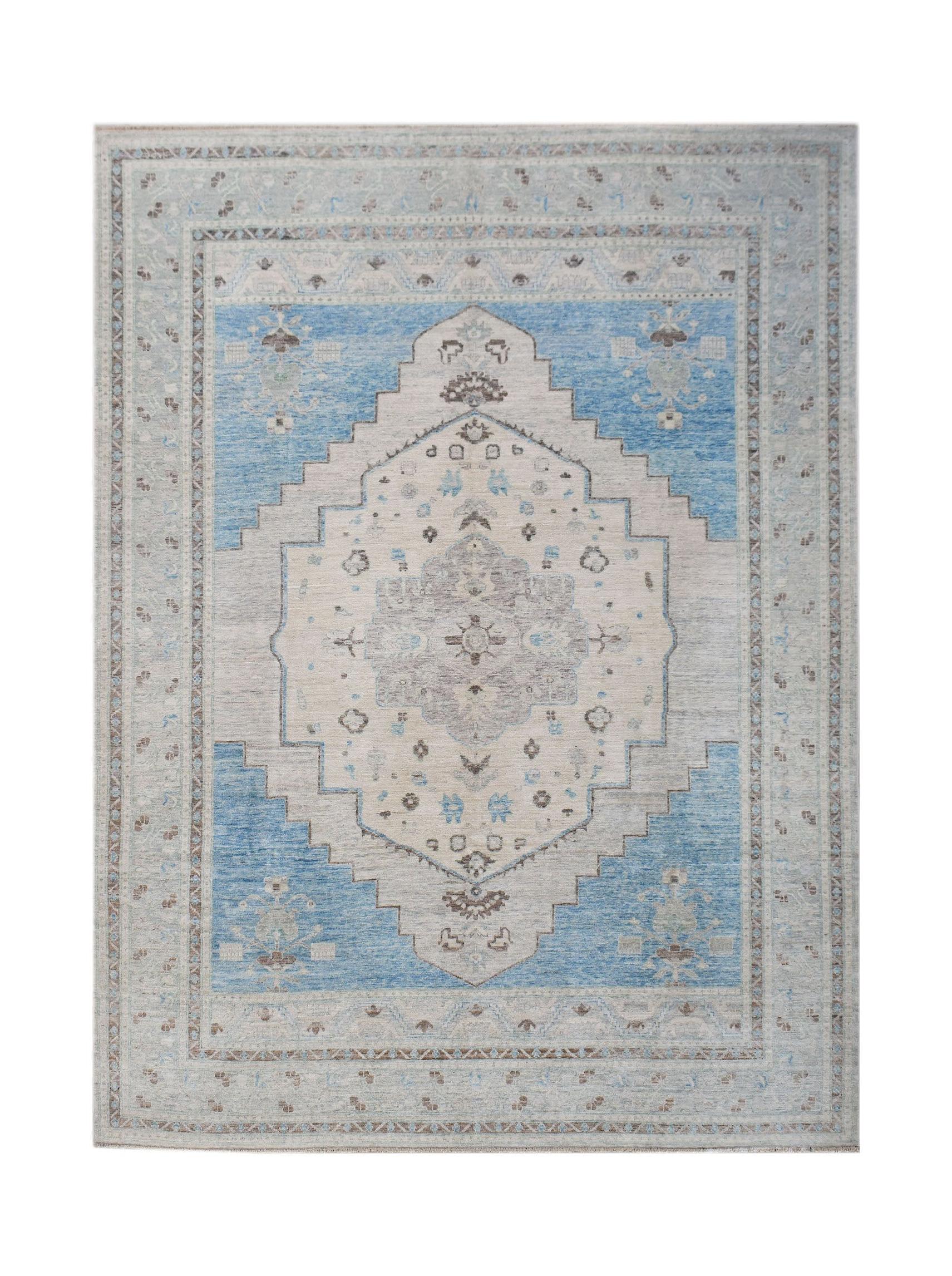 A handwoven transitional Oushak rug featuring a blue and cream floral medallion pattern.
