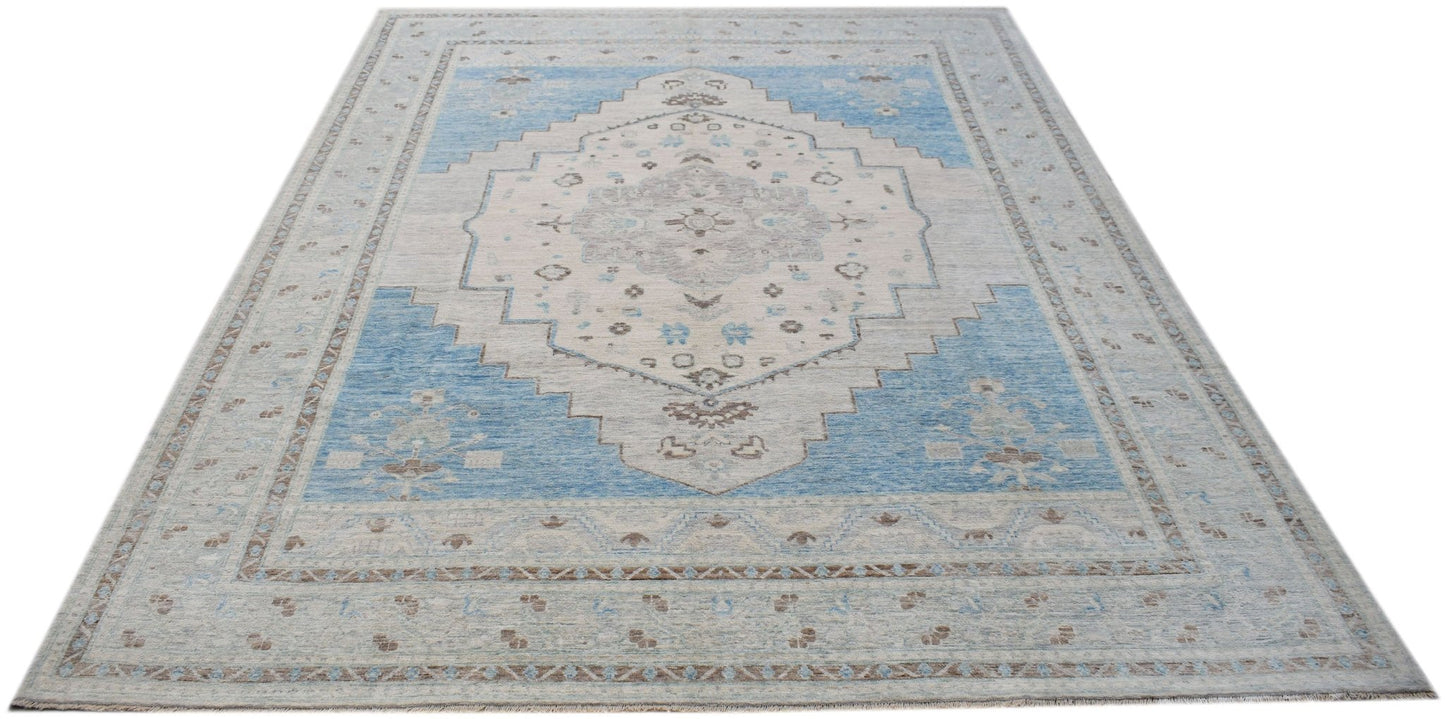 A handwoven transitional Oushak rug featuring a blue and cream floral medallion pattern.