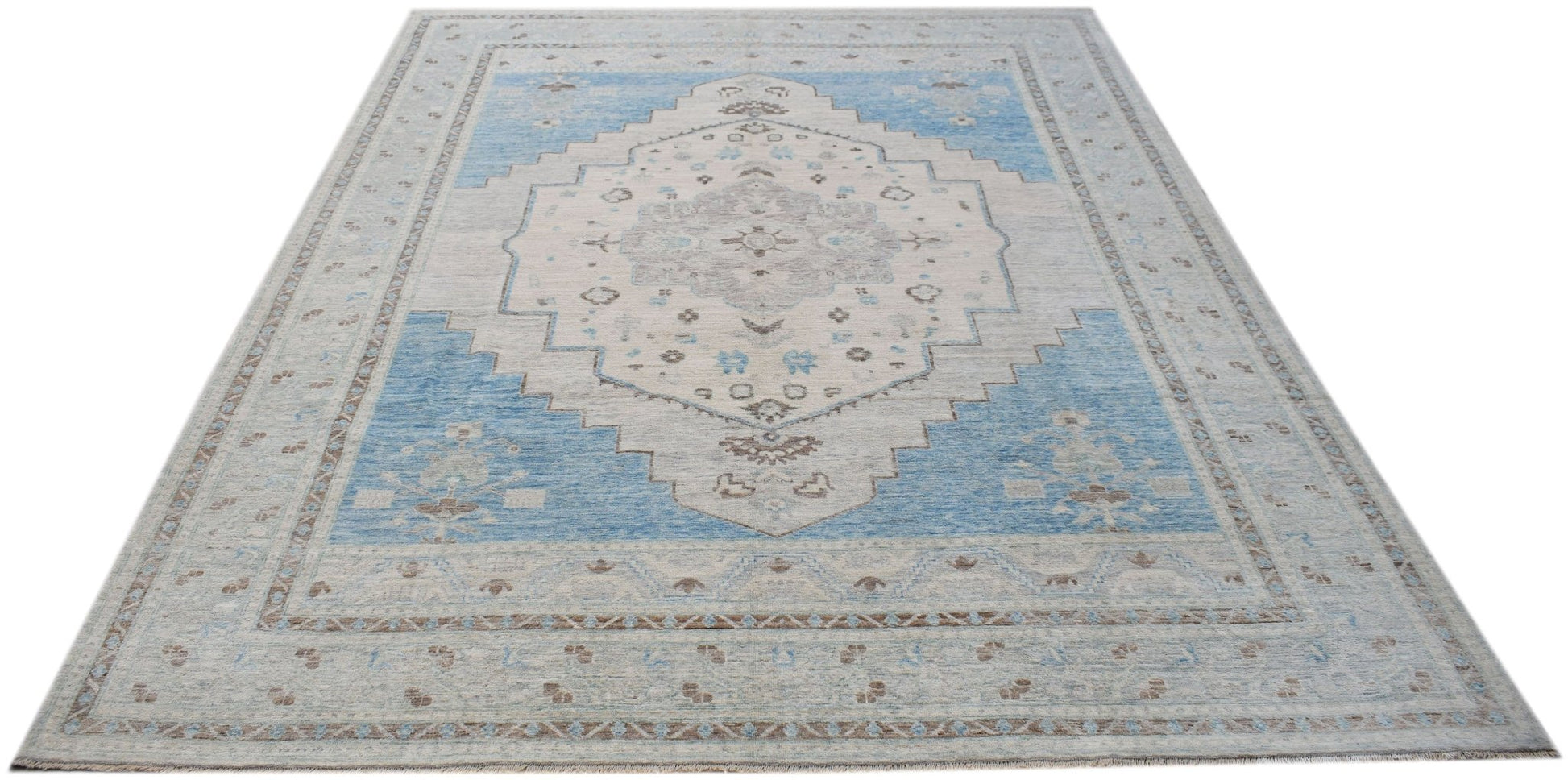 A handwoven transitional Oushak rug featuring a blue and cream floral medallion pattern.