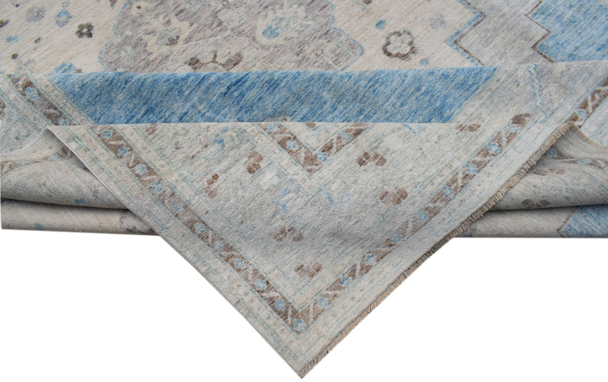A handwoven transitional Oushak rug featuring a floral pattern in blue, grey, and beige tones.