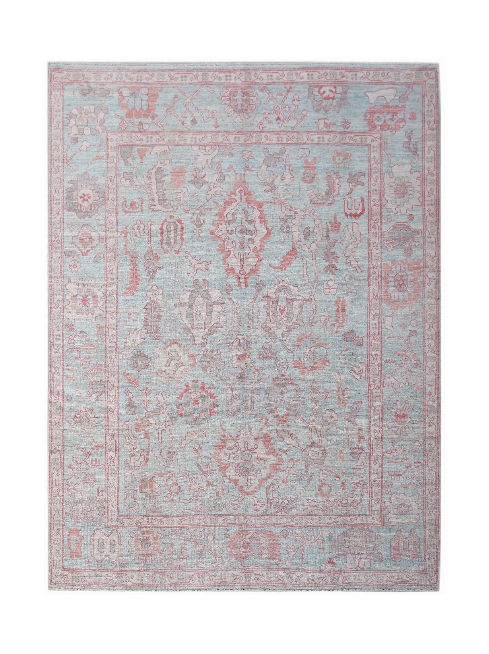 A handwoven transitional Oushak rug featuring a floral pattern in soft blue and pink tones.