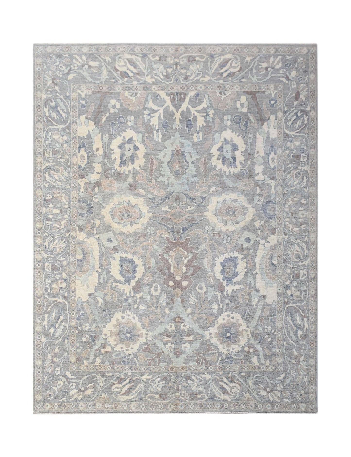 A handwoven transitional Oushak rug featuring a floral pattern in muted blue and grey tones.