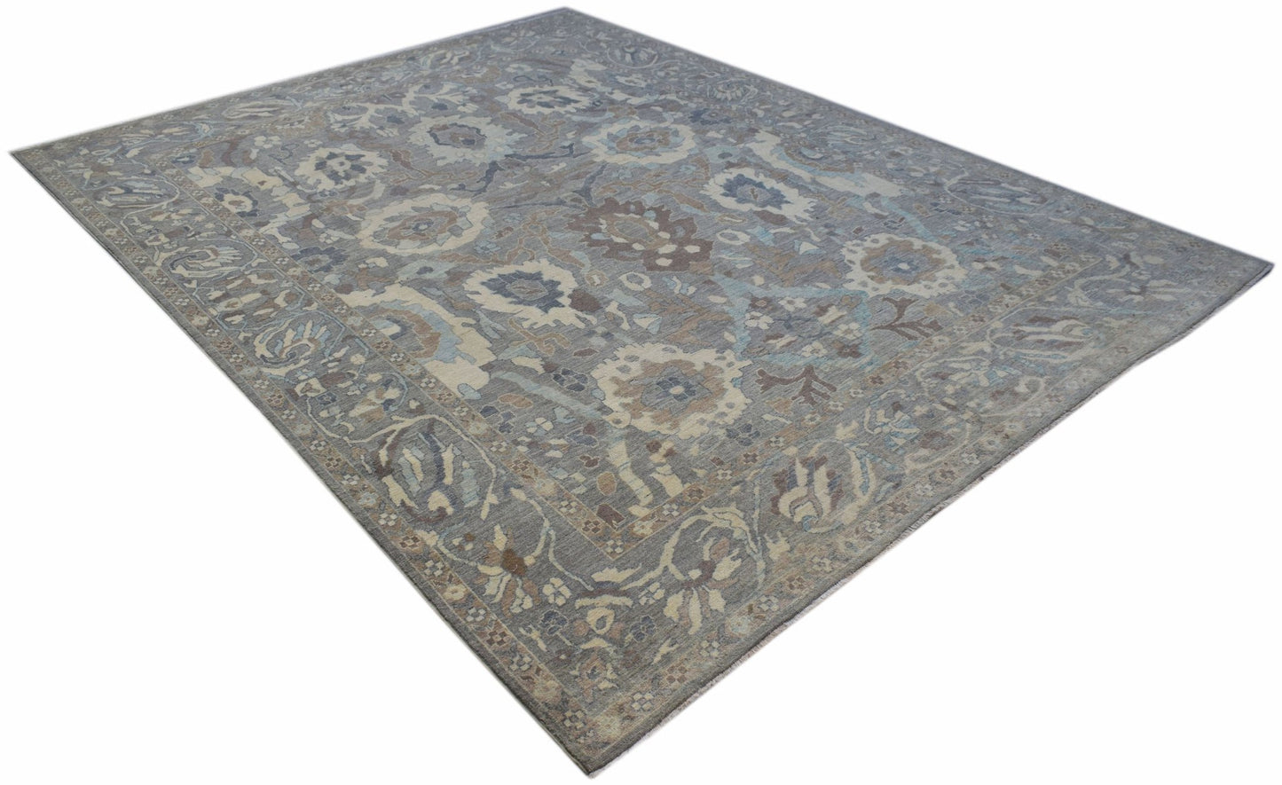 A handwoven transitional Oushak rug featuring a floral pattern in muted blue and brown tones.