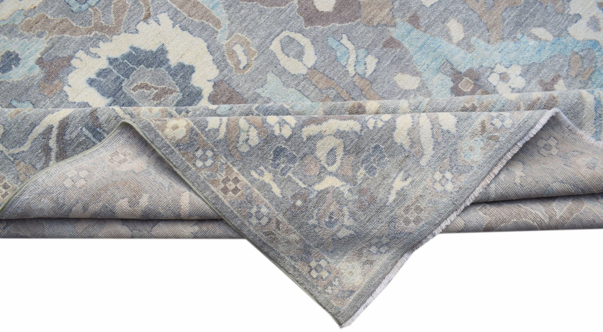 A handwoven transitional Oushak rug featuring a floral pattern in shades of blue, grey, and beige.