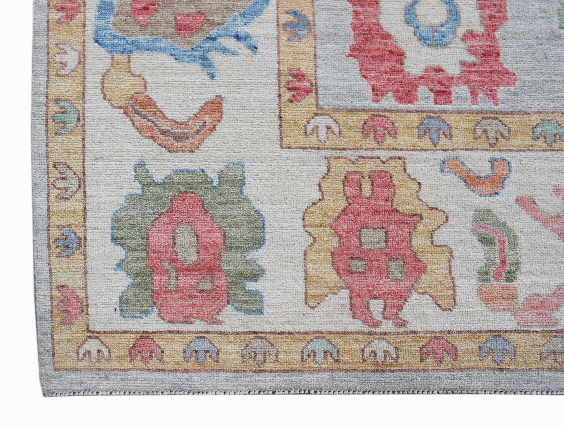 A handwoven transitional Oushak rug featuring a light background with colorful floral motifs.