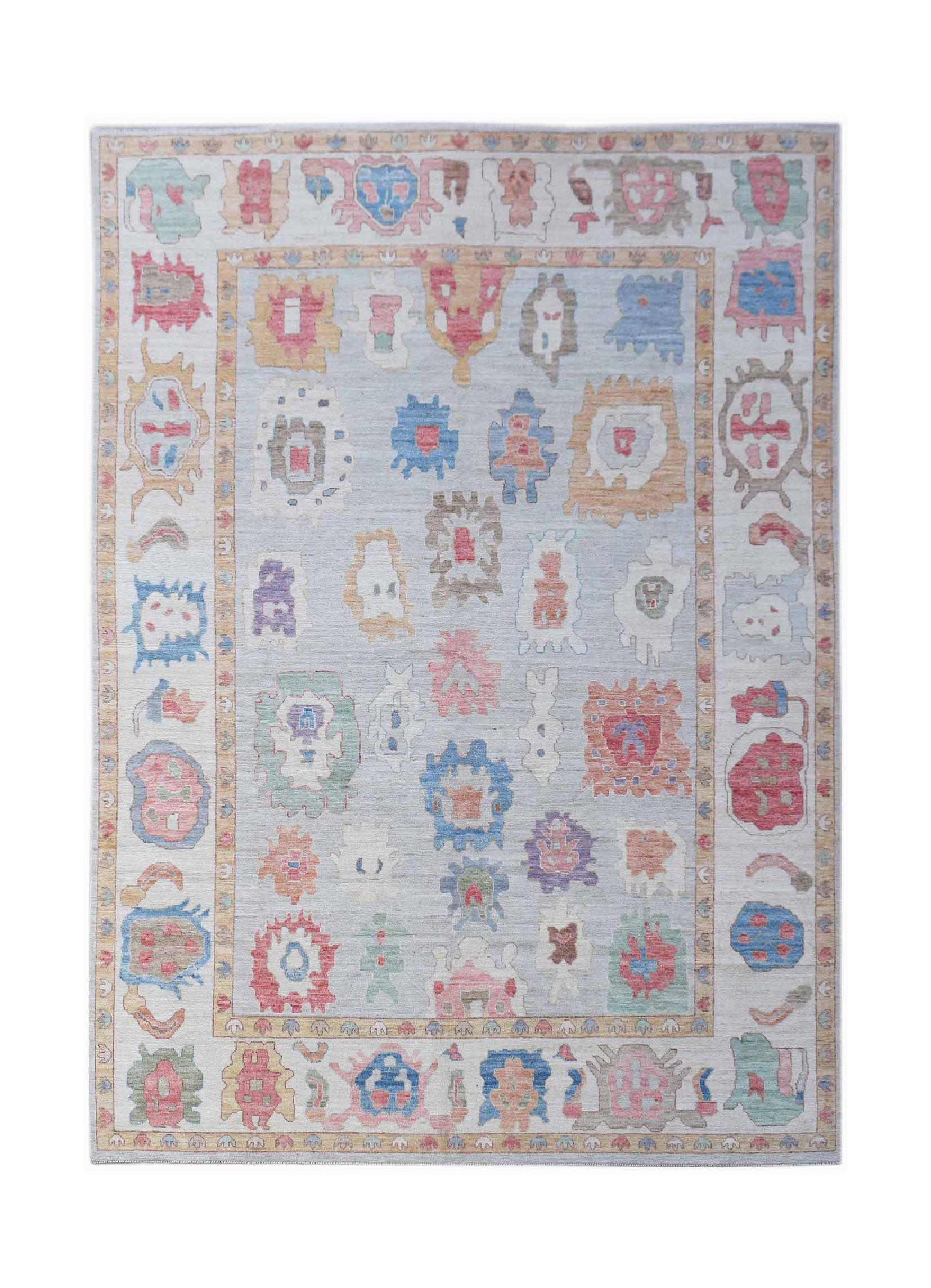 A handwoven transitional Oushak rug featuring a light blue field with colorful abstract motifs.