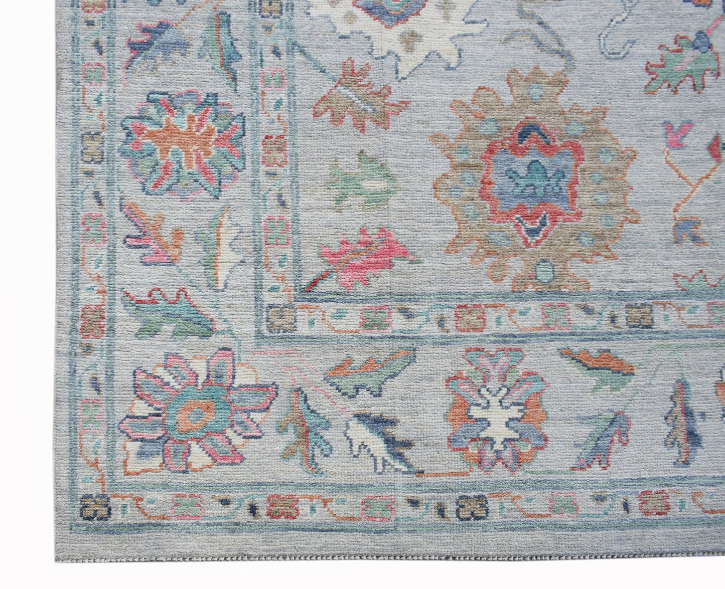 A handwoven transitional Oushak rug featuring a floral pattern in soft, contemporary colors.