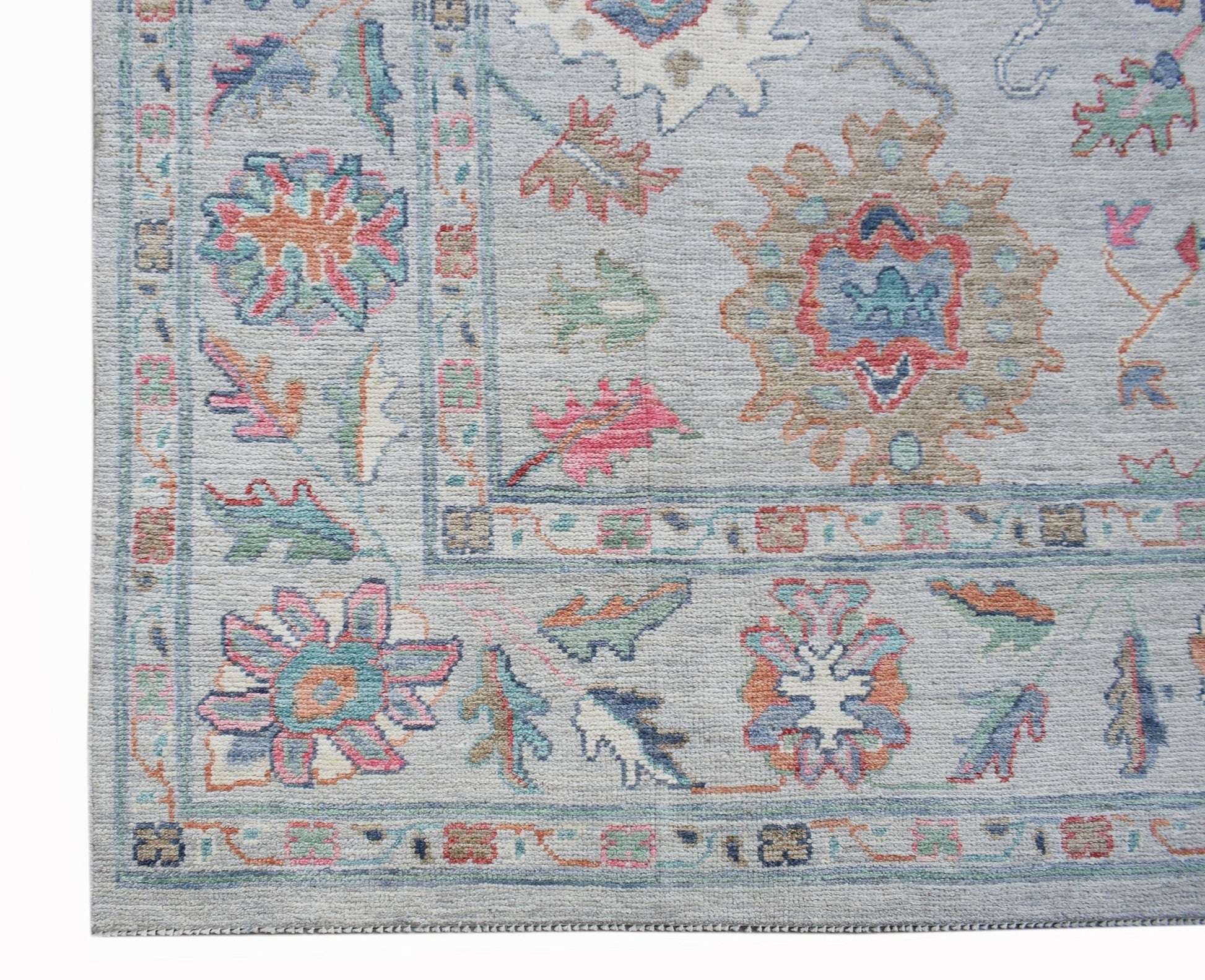 A handwoven transitional Oushak rug featuring a floral pattern in soft, contemporary colors.