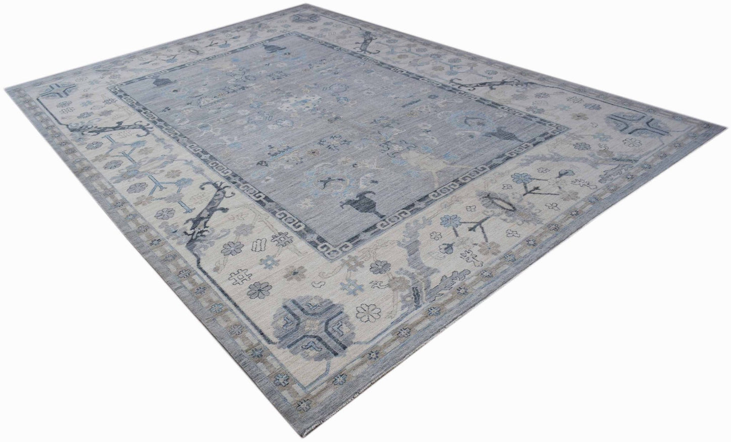 A handwoven transitional Oushak rug featuring a light blue and grey floral pattern.
