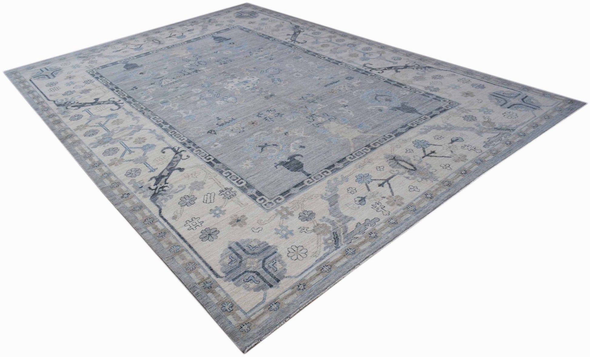 A handwoven transitional Oushak rug featuring a light blue and grey floral pattern.