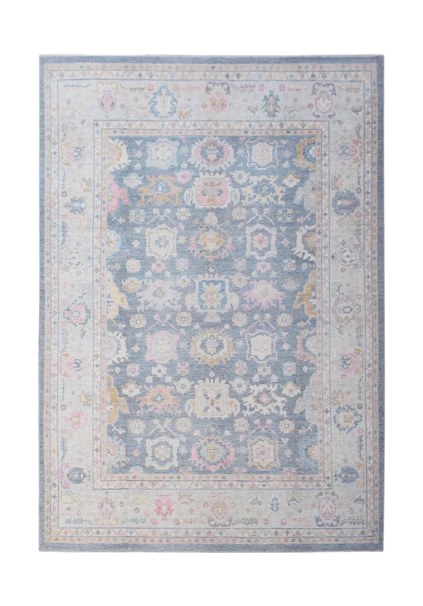 A handwoven transitional Oushak rug featuring a floral pattern in soft blue, pink, and cream tones.